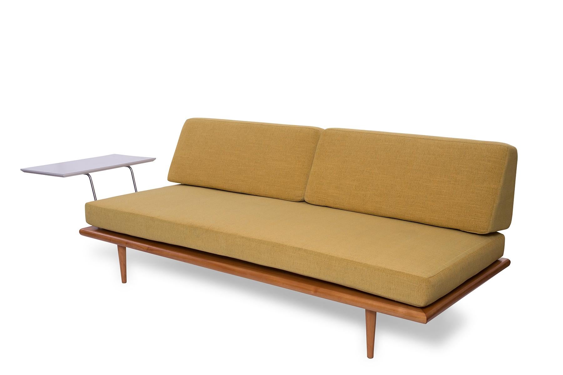This early George Nelson for Herman Miller daybed with mustard yellow upholstery features a seldom-seen side table arm. Please note that the length of the daybed measures 93.5 inches when including the extended arm table. Sofa has been newly