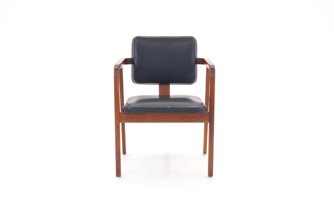 All original George Nelson armchair. Walnut frame, vinyl upholstery. Signed with the round Herman Miller medallion.