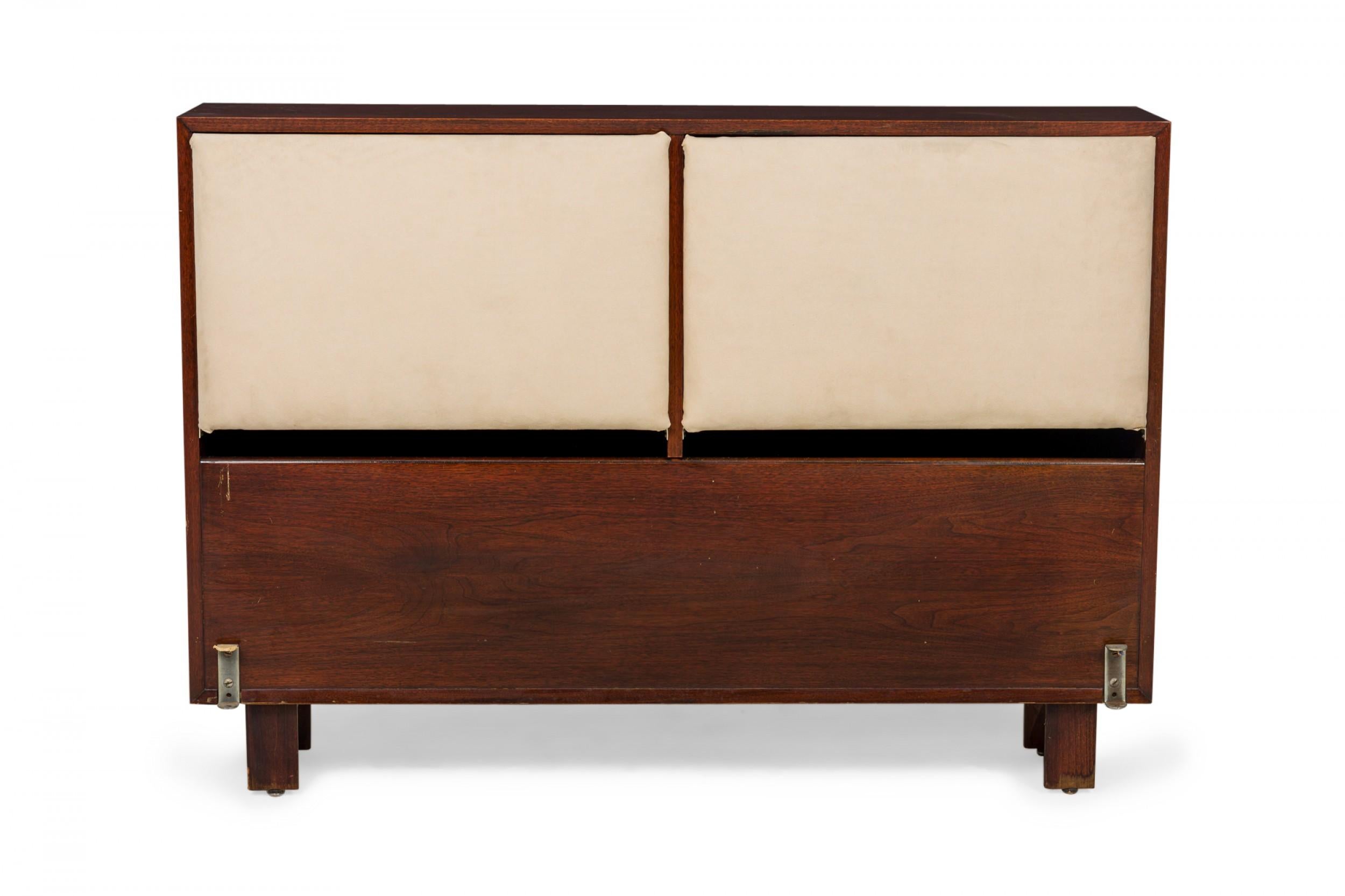 American Mid-Century double / full-sized bed headboard with a teak wood frame and two upholstered beige panels, resting on square wooden legs.
