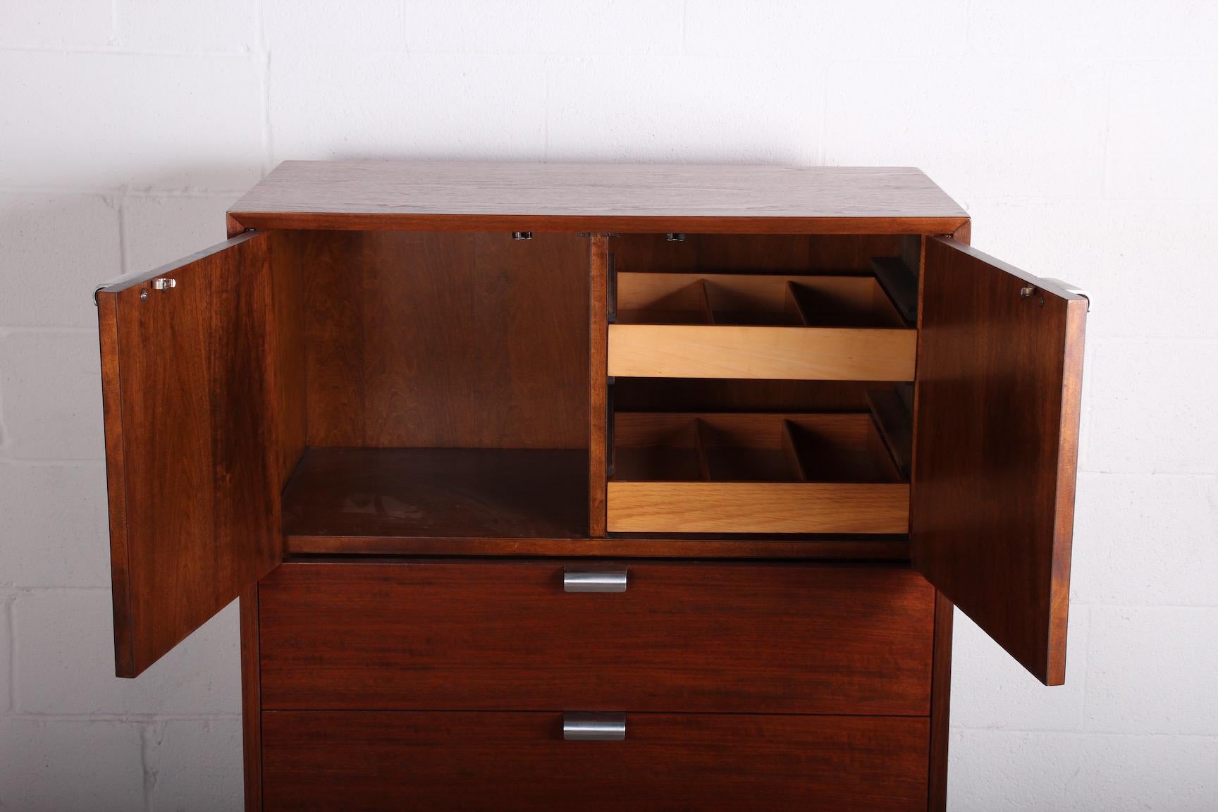 A walnut chest of drawers with aluminum pulls. Designed by George Nelson for Herman Miller.