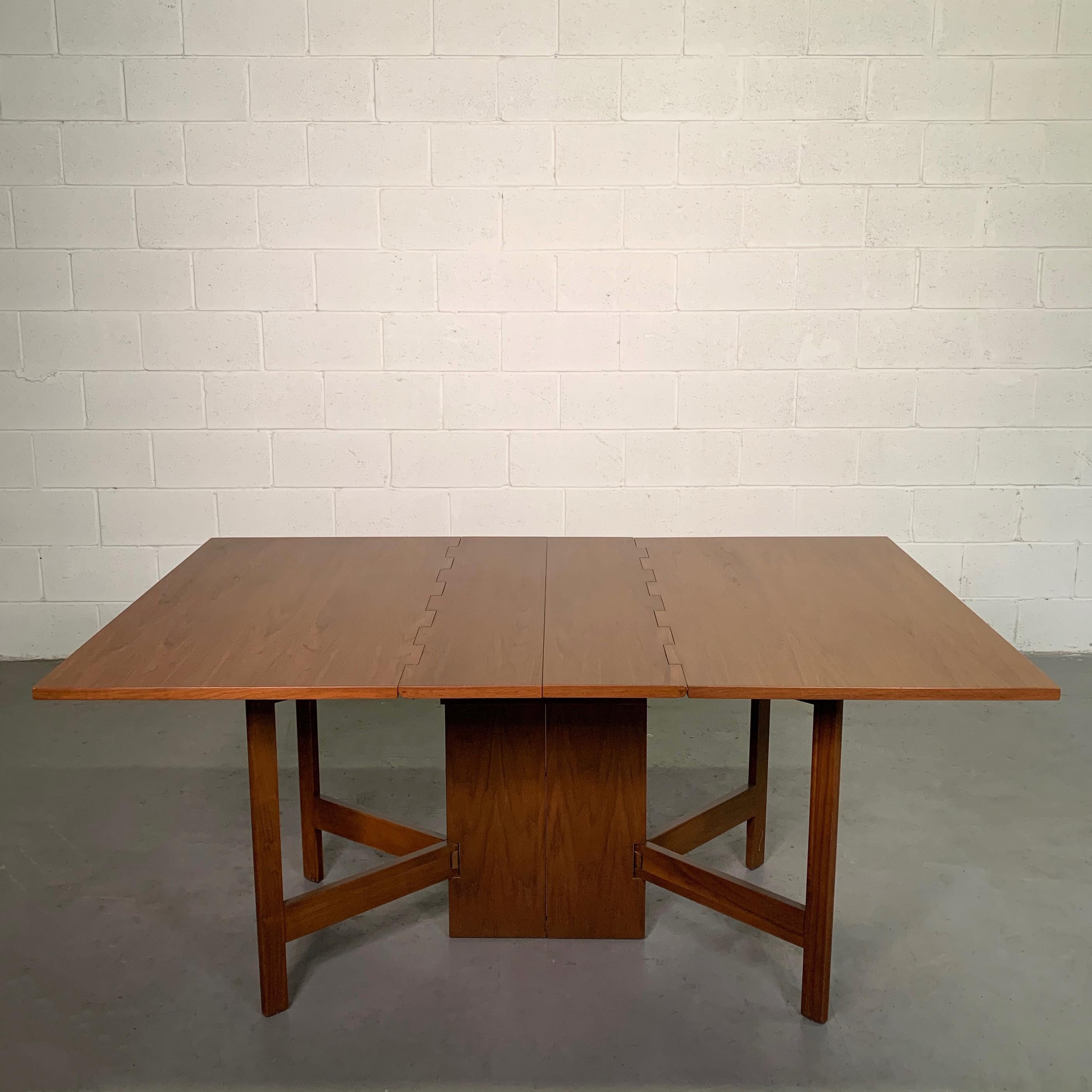 Mid-Century Modern, walnut dining table by George Nelson for Herman Miller features drop leaf, gate fold legs that bring the table to 18.5 inches when both folded.