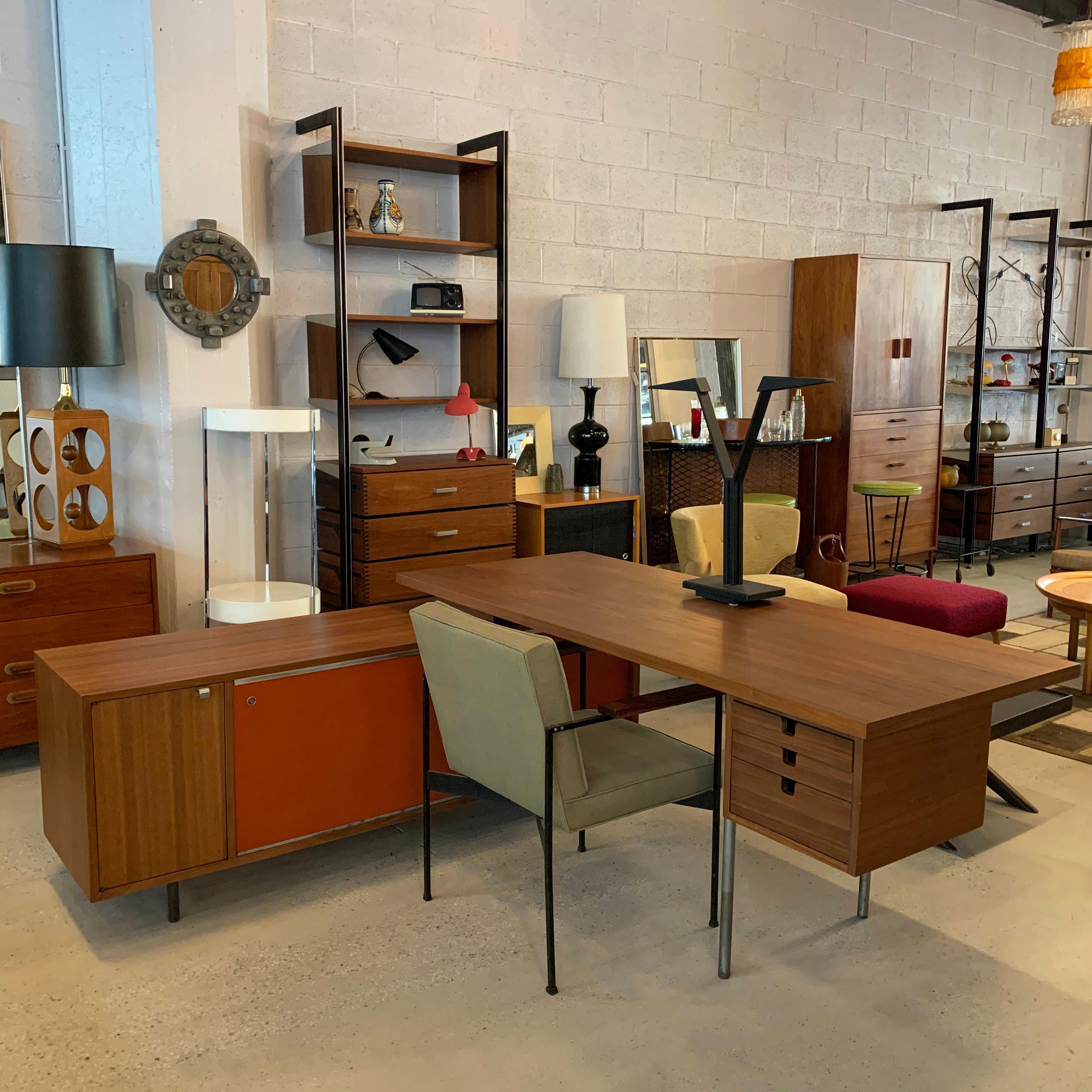 Mid-Century Modern, executive desk with credenza return by George Nelson for Herman Miller features a walnut desk with steel H legs that measures 72 x 30 x 29.5, with attached walnut office credenza with lacquered masonite sliding doors that