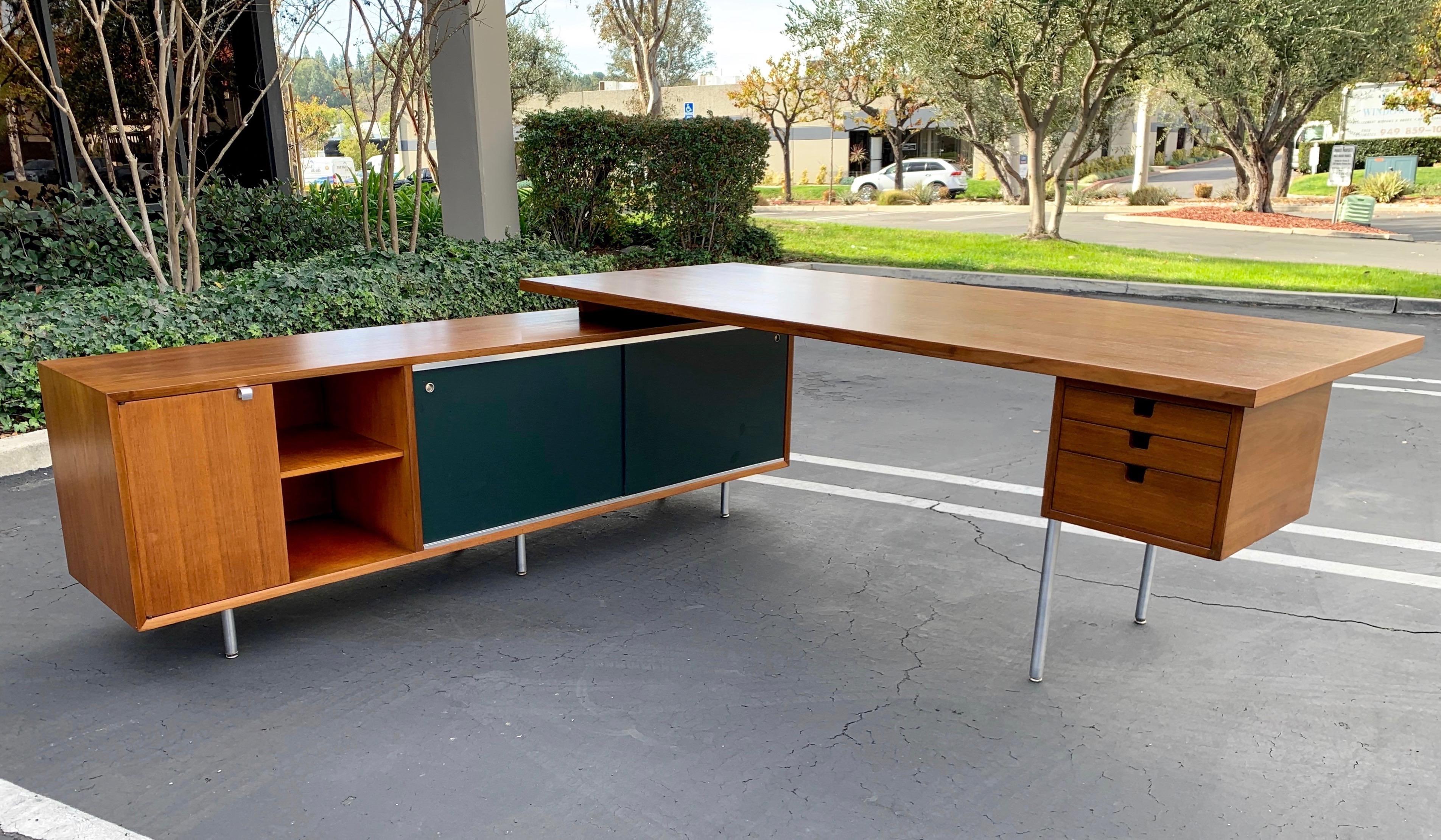 Mid-Century Modern, executive desk with credenza return by George Nelson for Herman Miller features a walnut desk with steel H legs that measures 84 x 36 x 30 with attached walnut office credenza with dark green almost black Masonite sliding doors