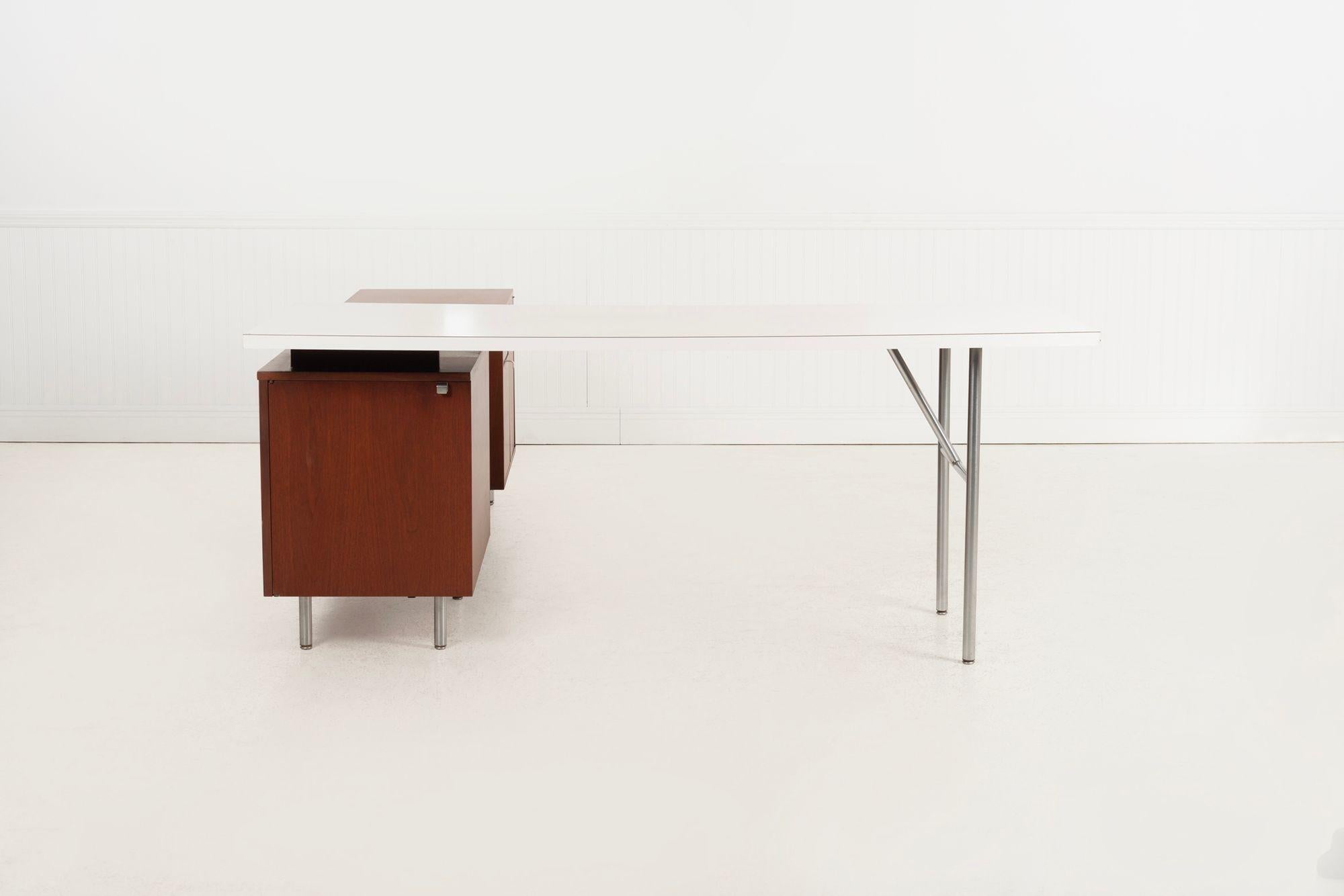George Nelson for Herman Miller Executive Office Desk and Return, 1955
Walnut case with laminate top and aluminum “H” base legs. The long cabinet is finished on all sides, featuring open storage, floating shelves, two drawers (including a pencil