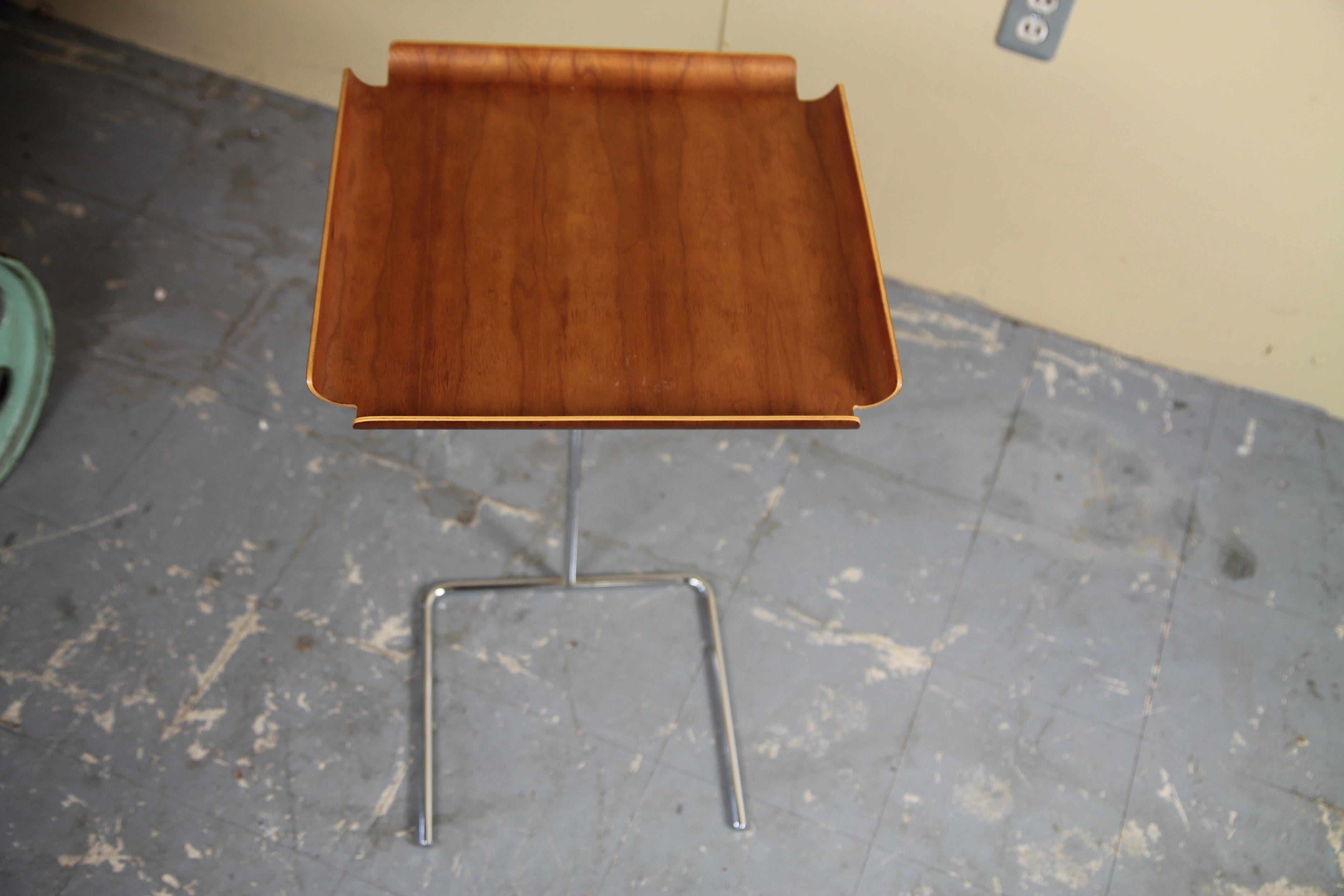 Adjustable tray table by George Nelson. Table is no longer in production. Table adjusts from 15.5 to 32 inches high. Also made to slide under a chair or couch so it extends over the piece of furniture.
