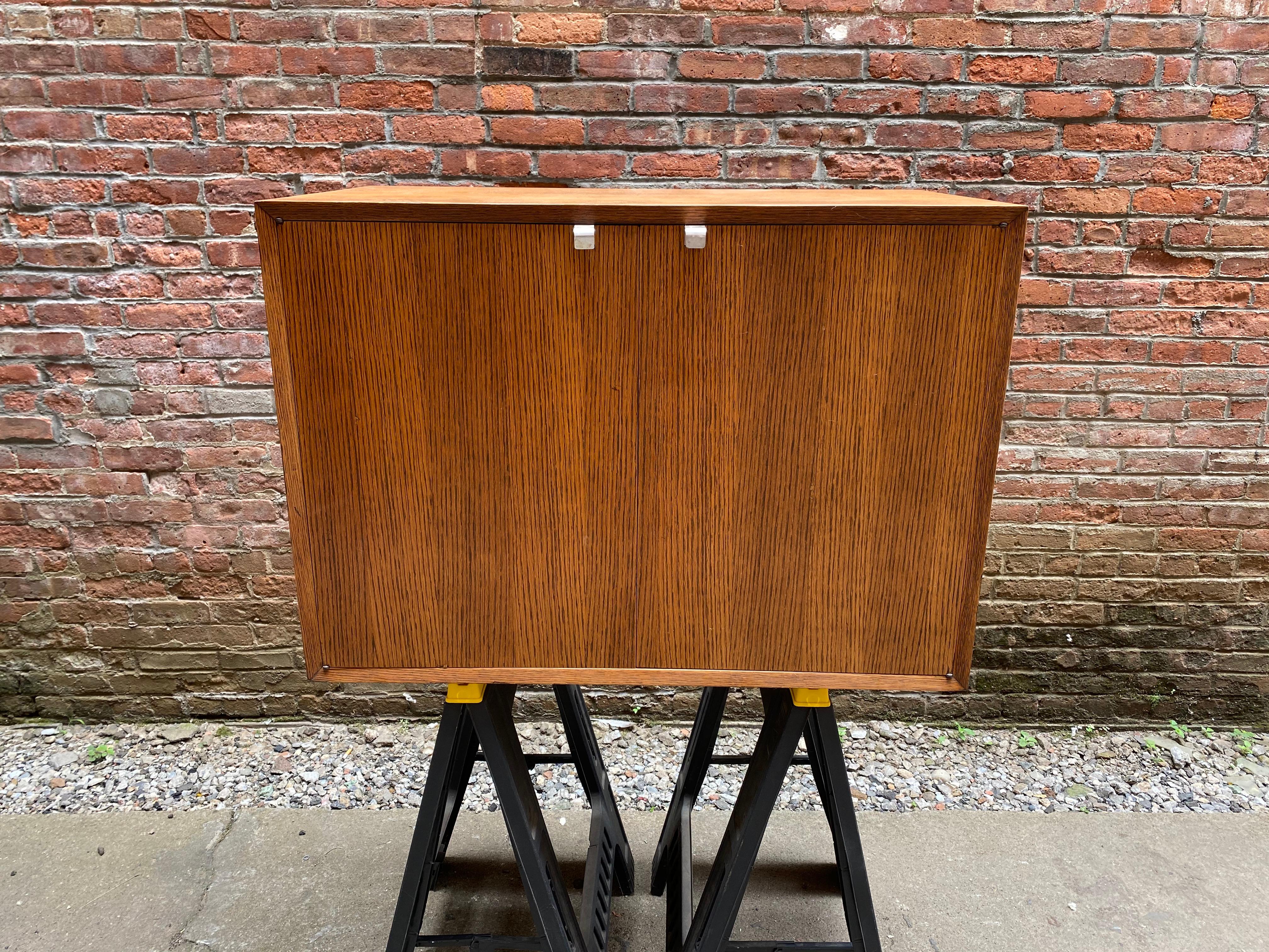 George Nelson for Herman Miller oak utility cabinet. A great addition for anyone trying to complete a slat bench. Oak veneer. Unsigned. Chrome J pulls. Single unfinished adjustable height plywood shelf. Older refinish, circa 1957.

Measures: