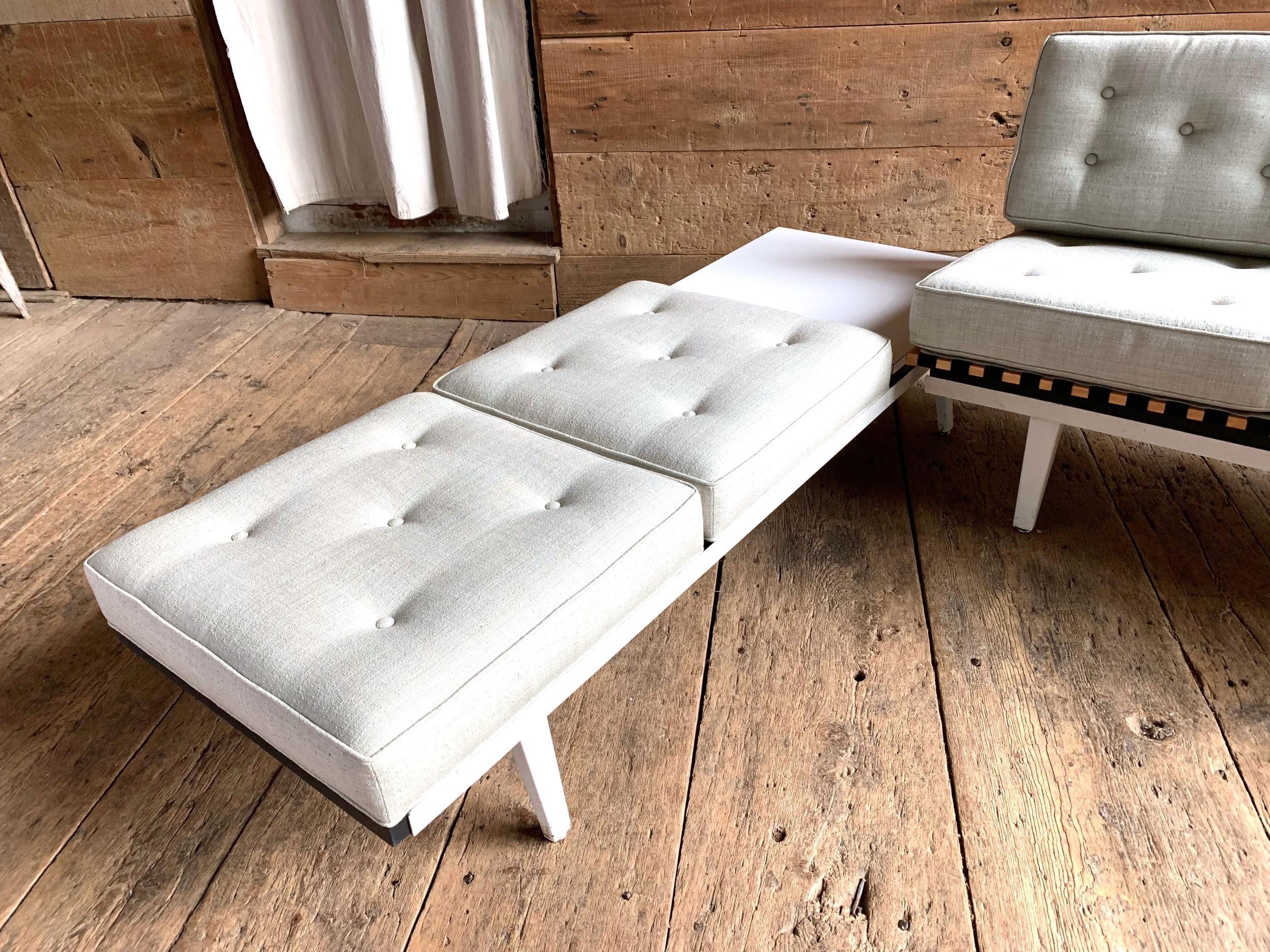 A George Nelson steel frame modular sofa in 2 sections with lift out folding seat frames and cushions allowing for reconfiguration, upholstered in light celedon fabric with original laminate table top, and original white painted steel frames, circa