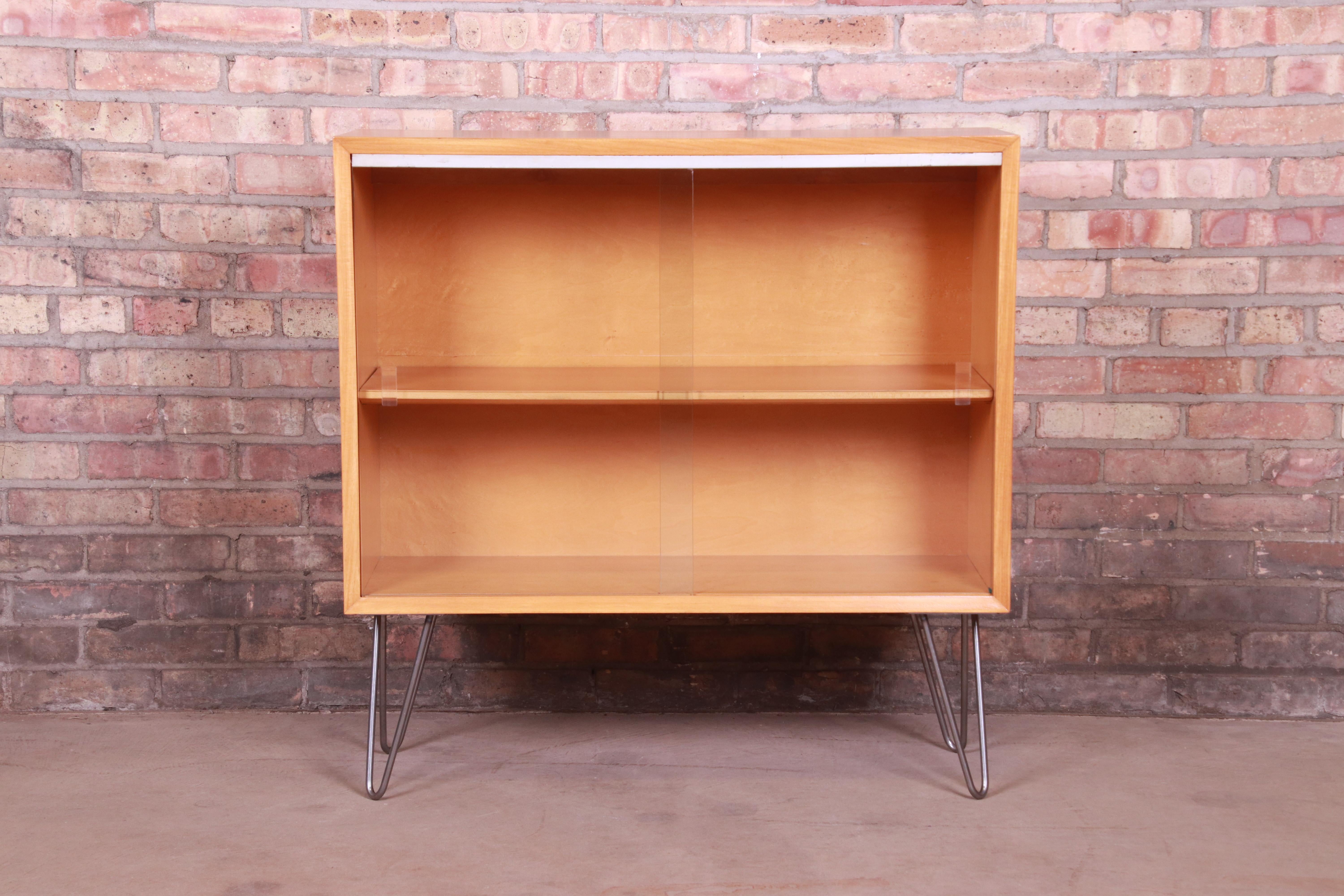 An exceptional Mid-Century Modern bookcase cabinet

By George Nelson for Herman Miller

USA, 1950s

Primavera wood, with aluminum trim, sliding glass doors, and steel hairpin legs.

Measures: 34