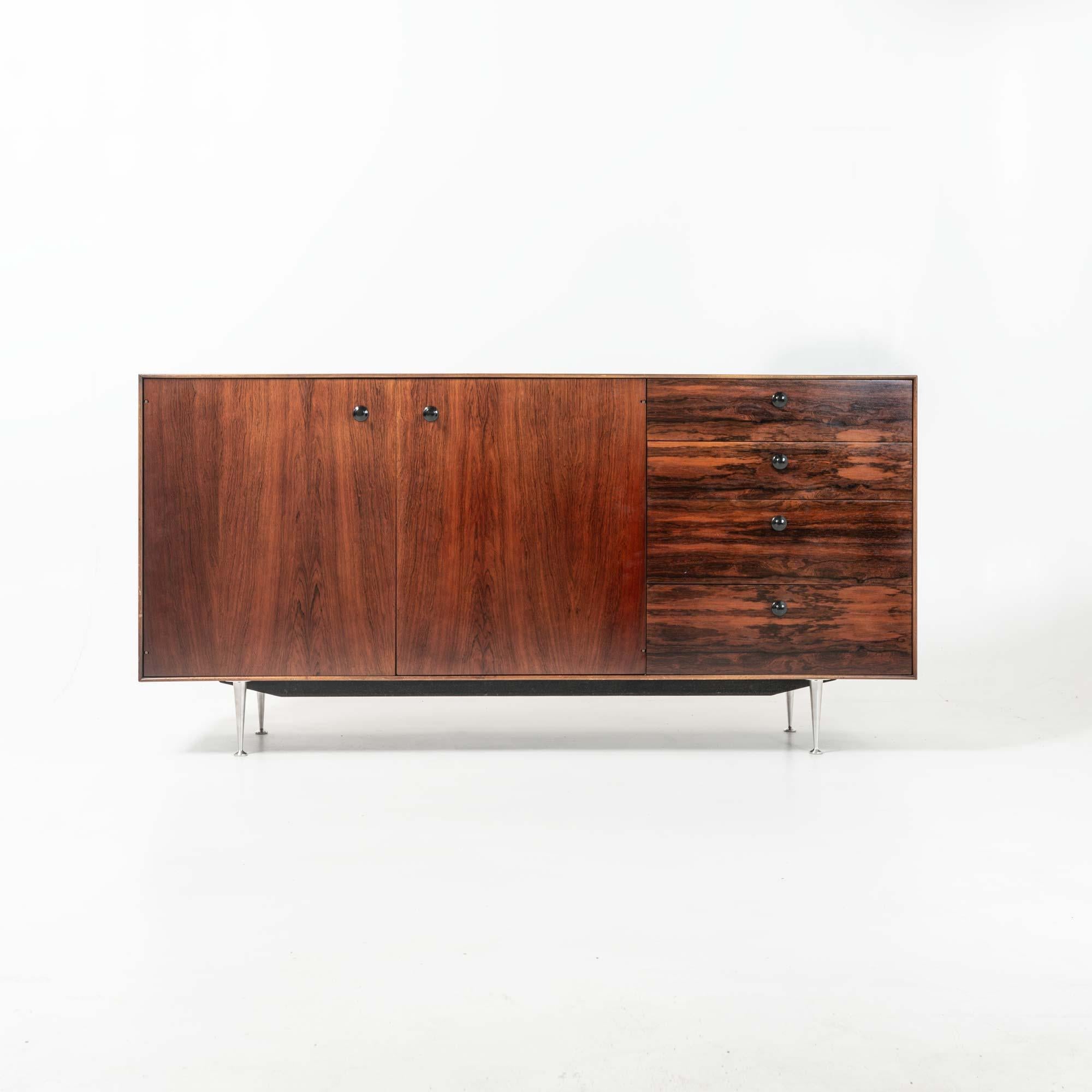 Una rara credenza/armario de borde fino de palisandro diseñada por George Nelson, producida por Herman Miller en los años 50, con 5 cajones (1 oculto tras la puerta) y dos estantes. Etiqueta de fabricante de lámina aplicada al cajón 