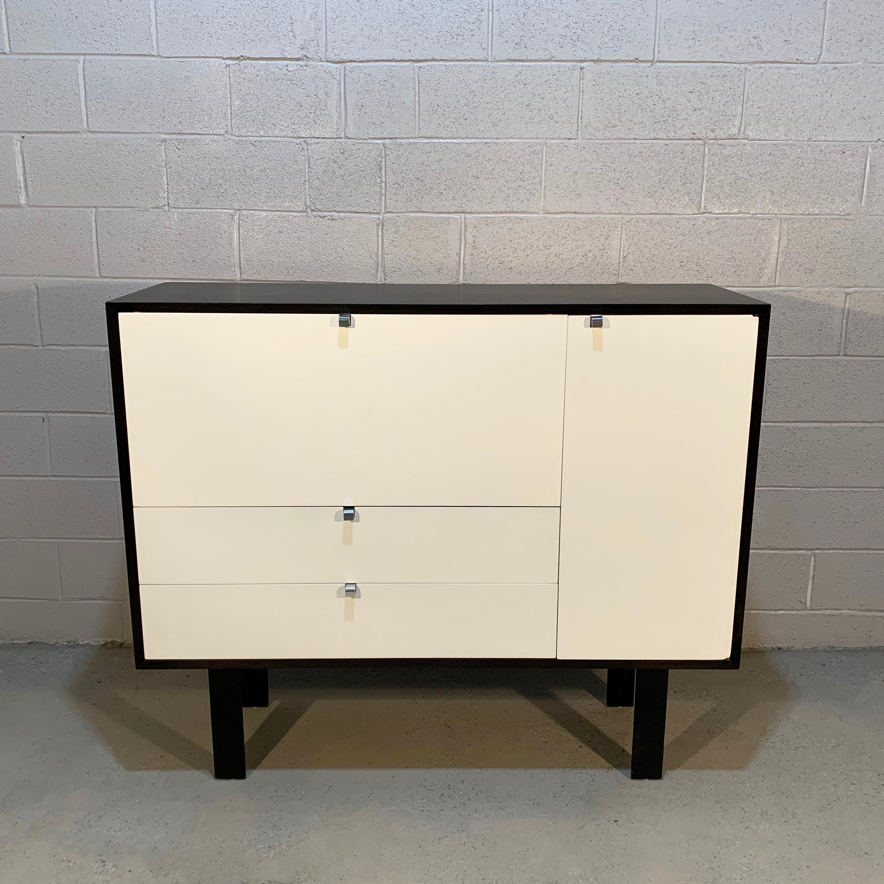 Mid-Century Modern, walnut, secretary cabinet by George Nelson for Herman Miller features a custom finish with white fronts framed in contrasting black with aluminum j pulls.