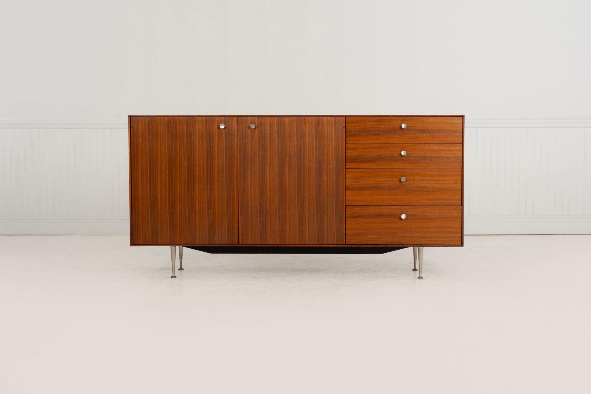 George Nelson for Herman Miller Thin Edge Credenza, Model 5724, 1957
Beautifully grained walnut case with quarter-sawn walnut doors. Features four drawers and a pair of doors concealing a pull-out drawer and adjustable shelves. Set on solid cast