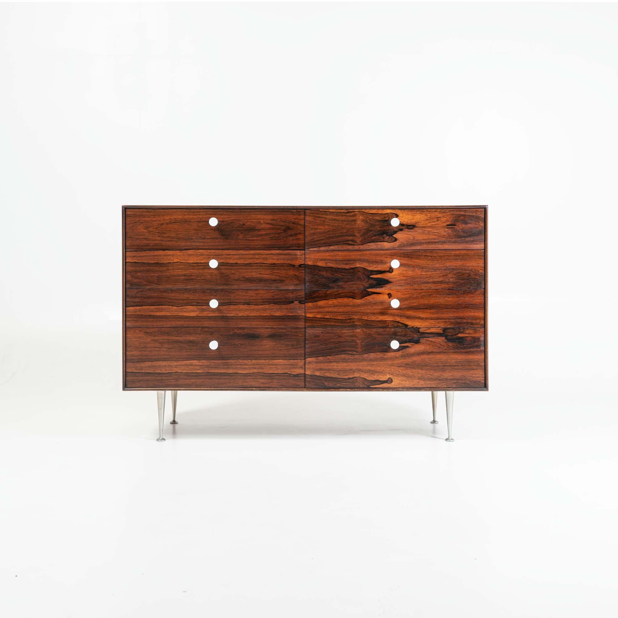 An 8 drawer dresser designed by George Nelson for Herman Miller, in Brazilian rosewood with its original white porcelain pulls and classic Thin Edge aluminum legs. The front drawers display exceptional rosewood grain, with great contrasts.  The