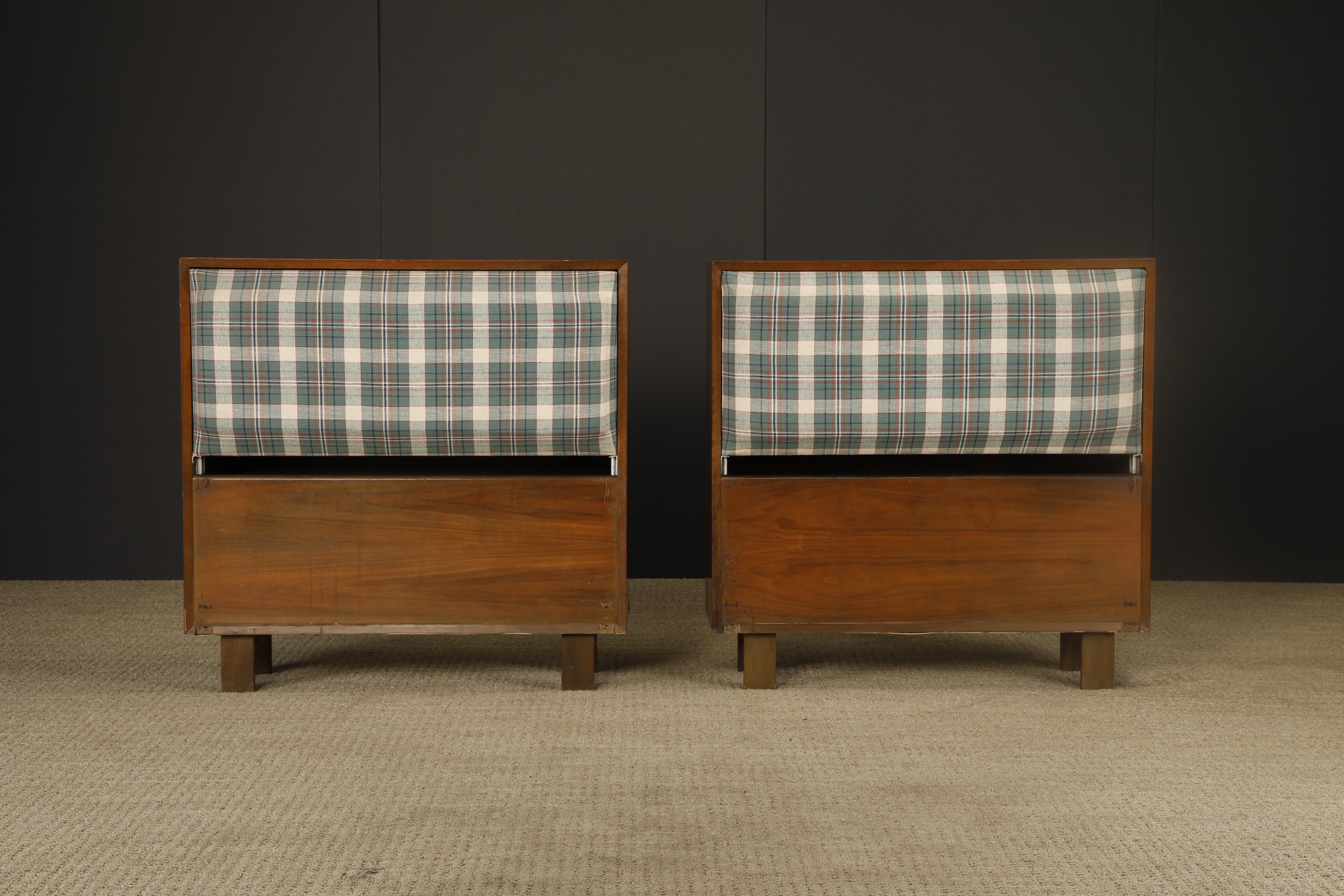 Un par de cabeceros gemelos de primera producción diseñados por George Nelson para Herman Miller, que presentan un ingenioso compartimento de almacenamiento oculto que se abre para revelar un almacenamiento interior con estante. Fabricados en nogal