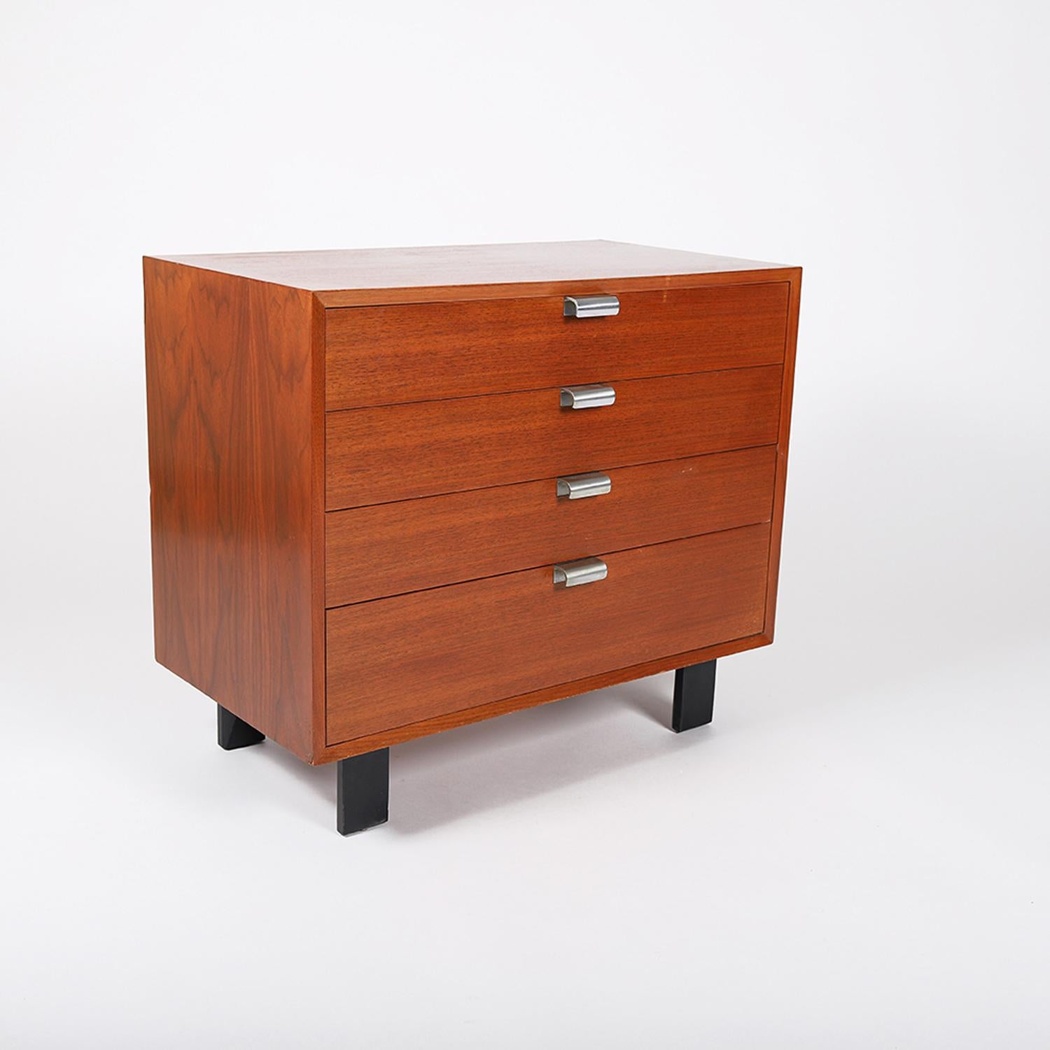 An American MCM 4 drawer chest designed by George Nelson for Herman Miller. A lacquered walnut case, black lacquered angular legs with cast aluminum drawer pulls. Top drawer has removable dividers. 

Professional, skilled furniture restoration is an