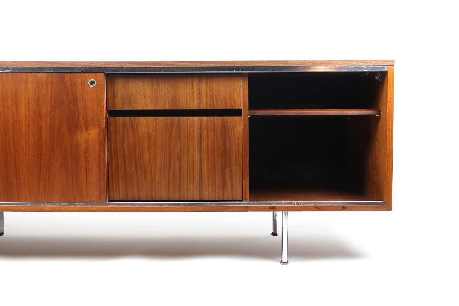 An exceptional Mid-Century Modern George Nelson Executive Office Group credenza for Herman Miller. Walnut case with rich grain and original finish, well preserved walnut laminate top, chrome accents and legs, and two walnut veneer sliding doors with