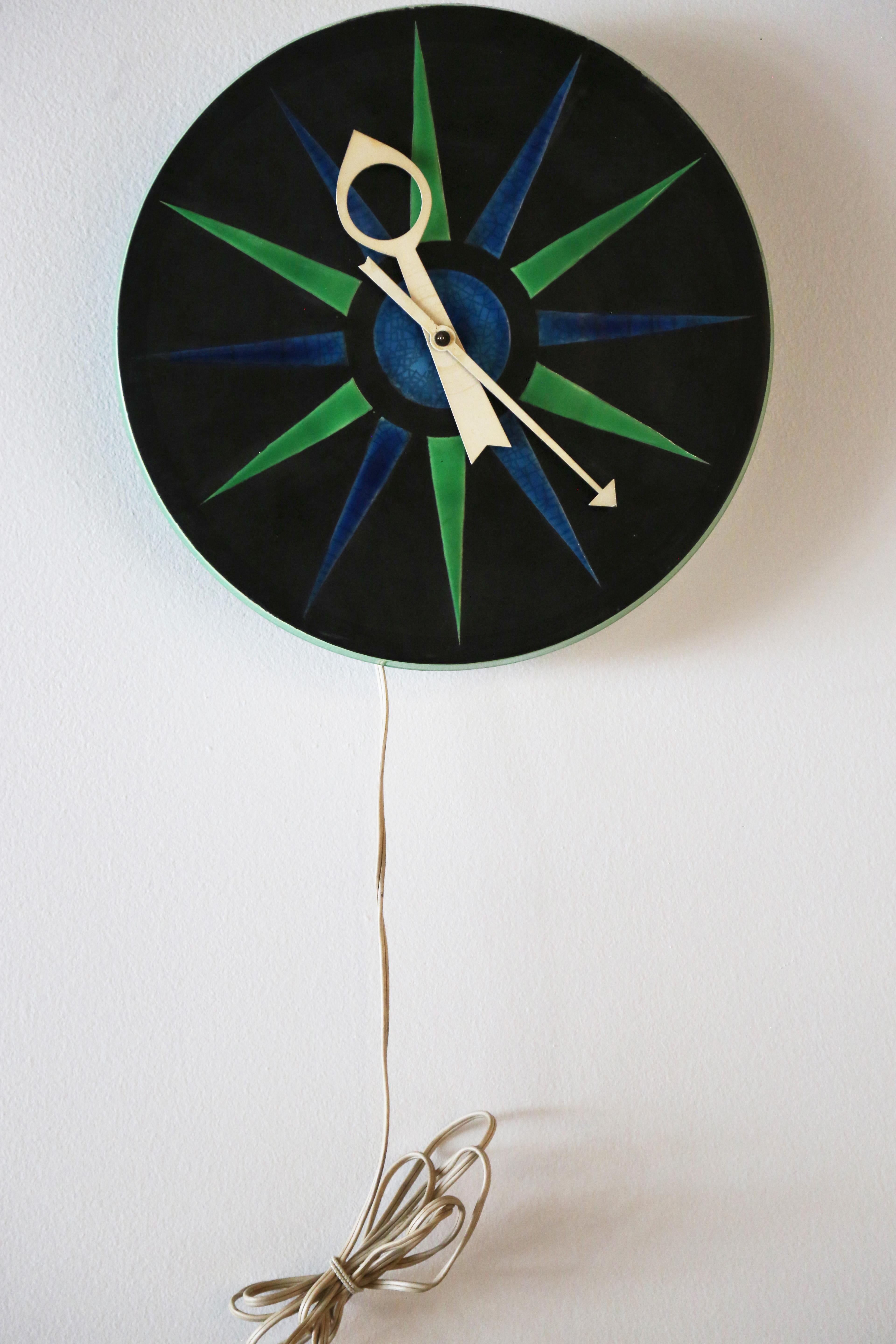 Mid century modern ceramic clock, model 7546, designed by George Nelson and Associates for Howard Miller. The ceramic clock was made in Italy under the meridian division for Raymor, and includes a beautiful mix of neon green and crazed blue glazes