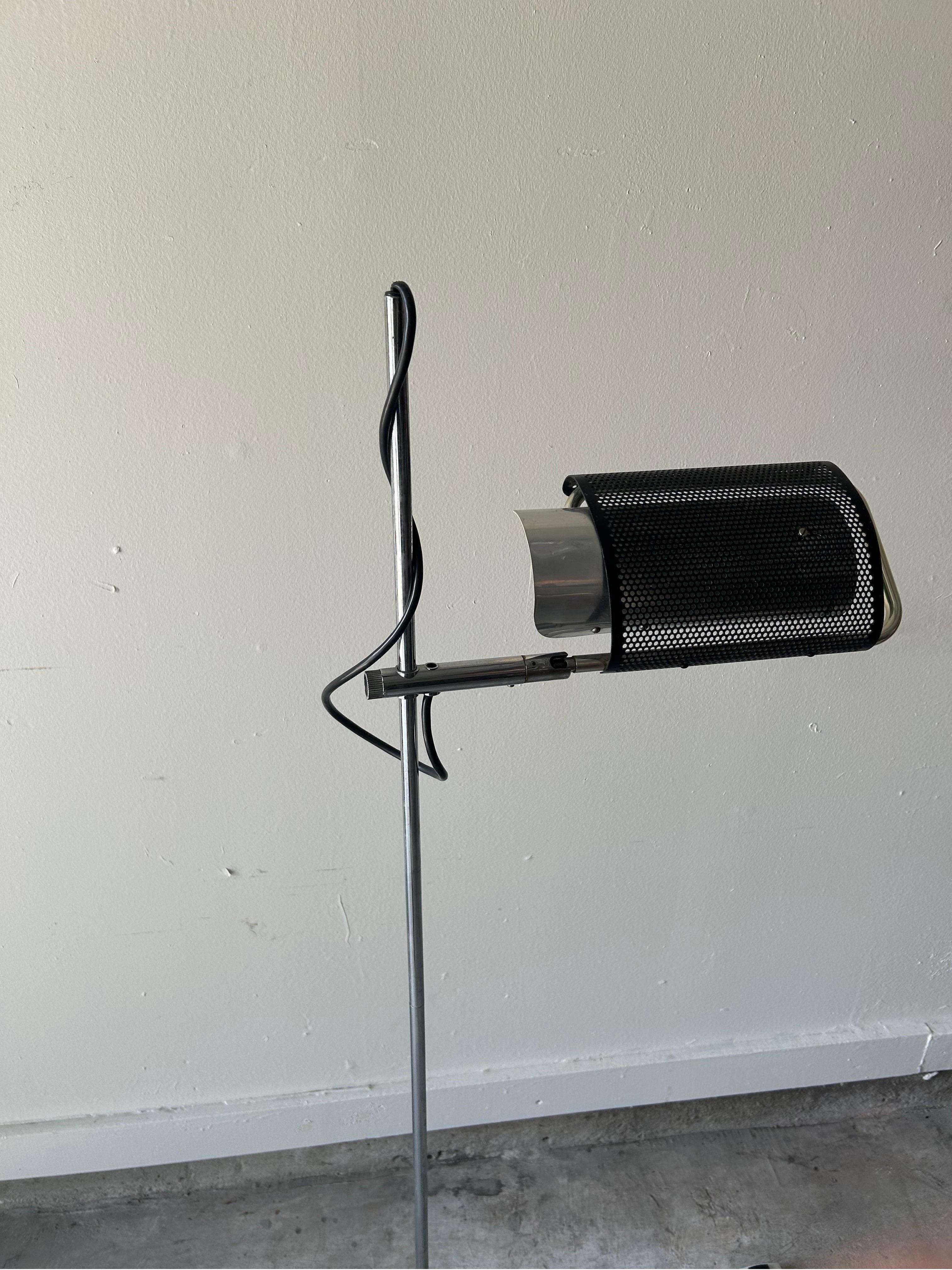 Modern George Nelson for Koch & Lowy Adjustable Perforated Black Floor Lamp. Featuring a perforated Black enameled Aluminum cylinder mesh shade, Off White interior, articulating Chrome arm with round Black Iron base. Shade tilts horizontally or