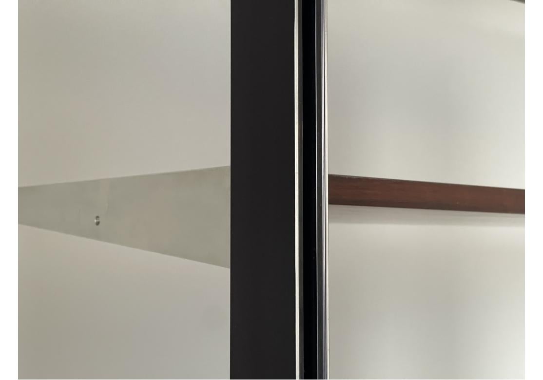 Probably by George Nelson 1960's. An exceptional large scale wall unit with three compartments. Tall heavy black powder coated adjustable height metal frames with other metal legs. 
Three wooden units- a storage unit with tambour doors and shelves