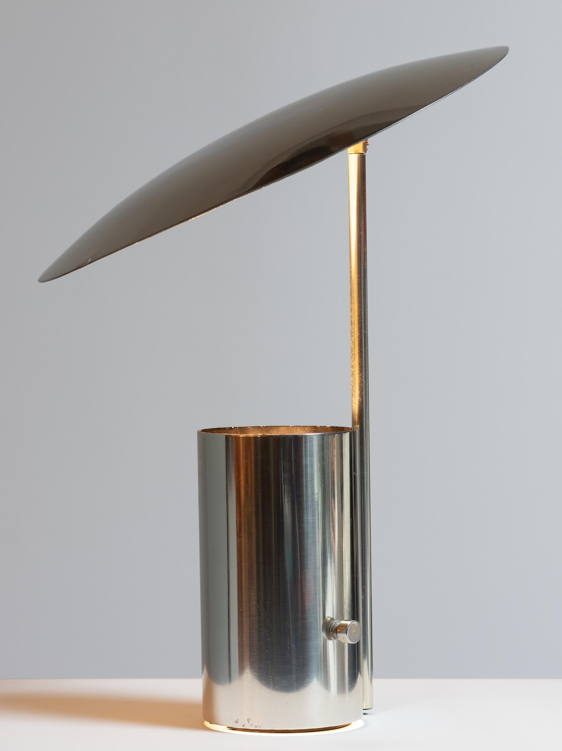Half Nelson table lamp, designed by George Nelson for Koch and Lowy. A thoughtful design, featuring a pivoting shade made from spun aluminum, that offers customizable illumination. Two-way light source is hidden within the cylindrical base. The