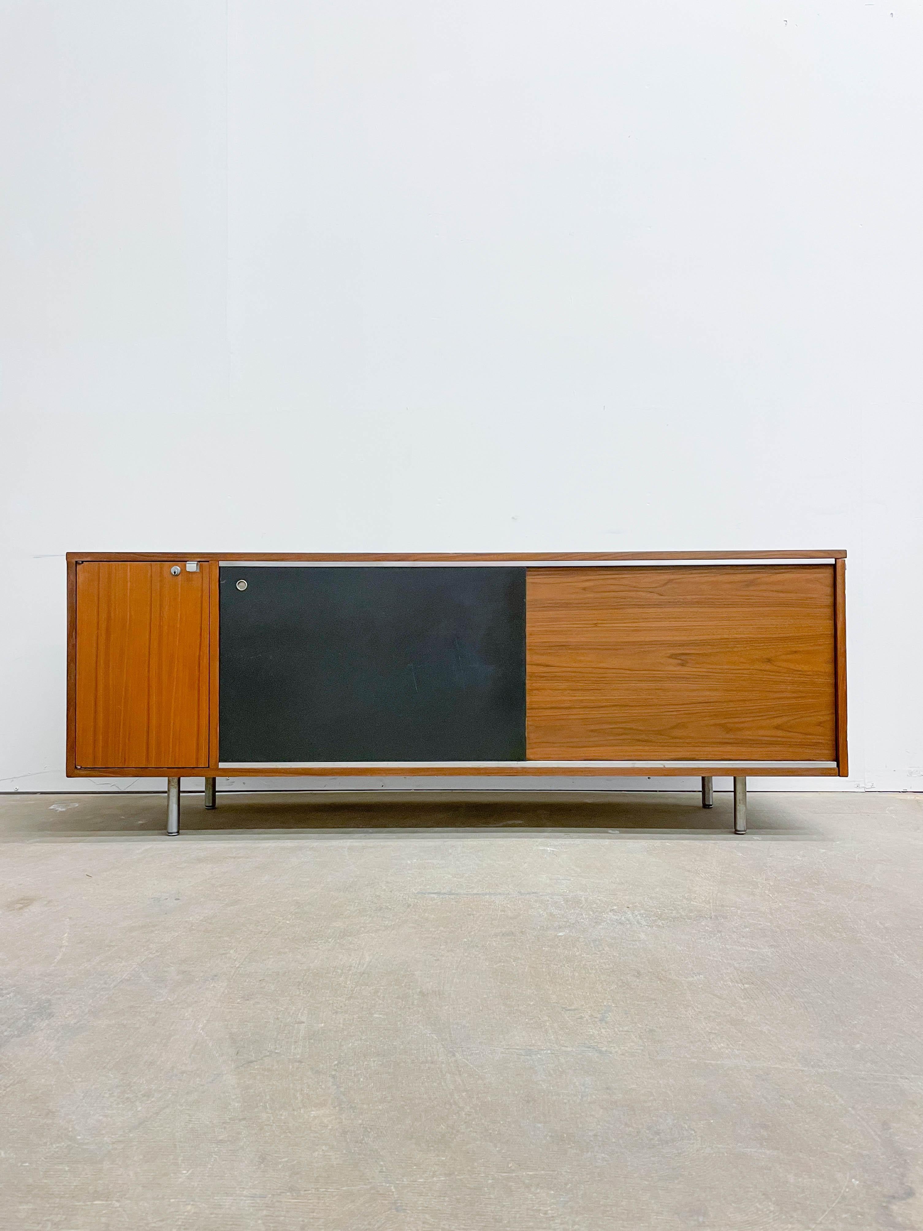 Early edition Credenza from George Nelson’s executive office group (EOG) from the early 1950s. This piece offer excellent storage in a variety of forms. There are five drawers behind the sliding panel, including one hanging file drawer, one large