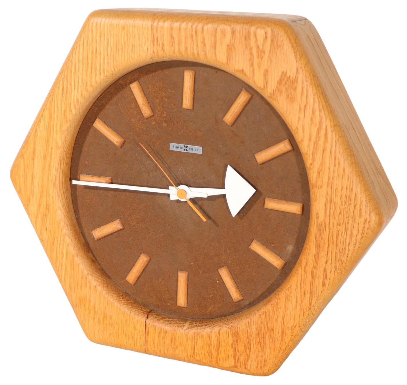 Groovy Post Modern wall clock having a hexagonal frame of solid oak, with an ultra suede face, and metal hands. The clocks in good, original, clean and working condition, showing light cosmetic wear and signs of age and use. 
 Specifically, some