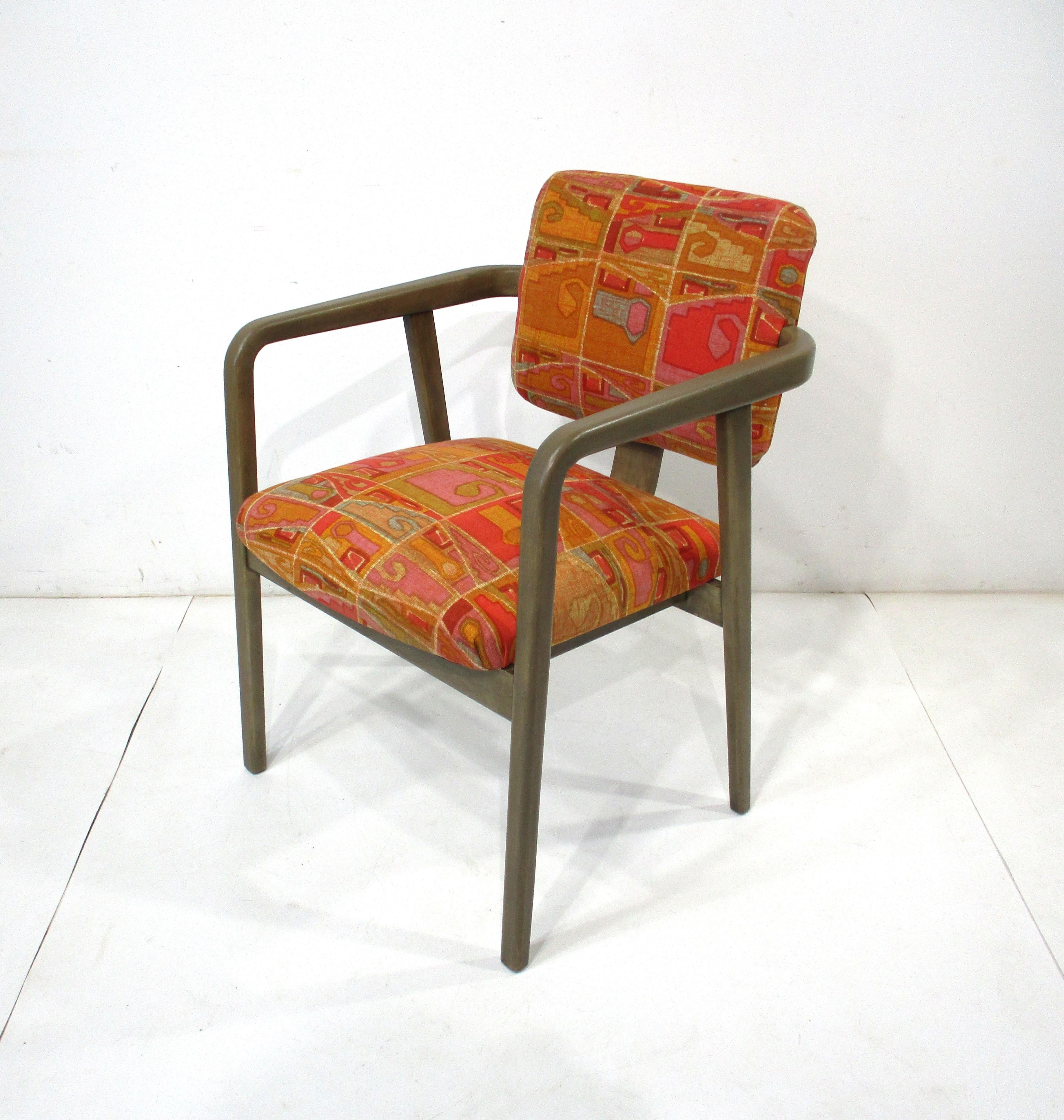 Un escultural sillón curvado de madera de abedul con tapicería de tela de colores personalizados de Jack Lenor Larsen . Esta silla de principios de los años 50 de la era del Medio Siglo es perfectamente cómoda para una sala de estar o un dormitorio