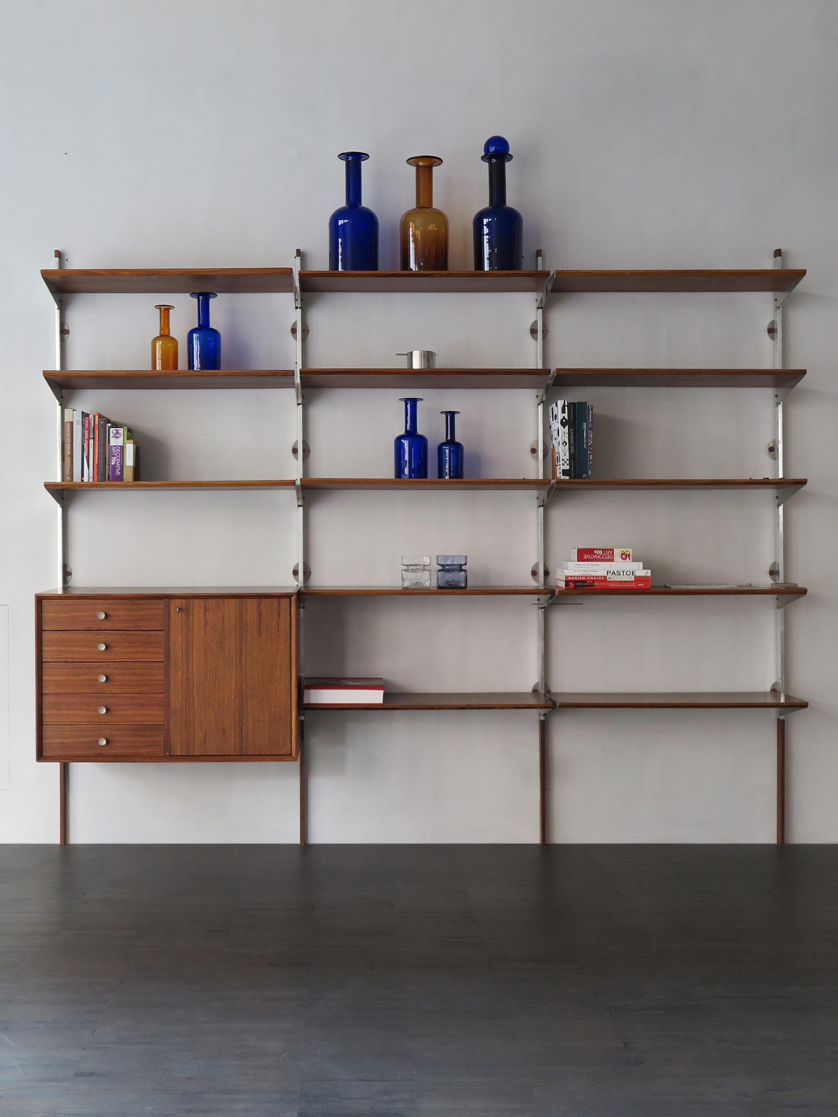 Dark wood wall system designed by George Nelson for Herman Miller with movable shelves, aluminum detail, circa 1950s.
Please note that the wall system is original of the period and thus shows normal signs of age and use.