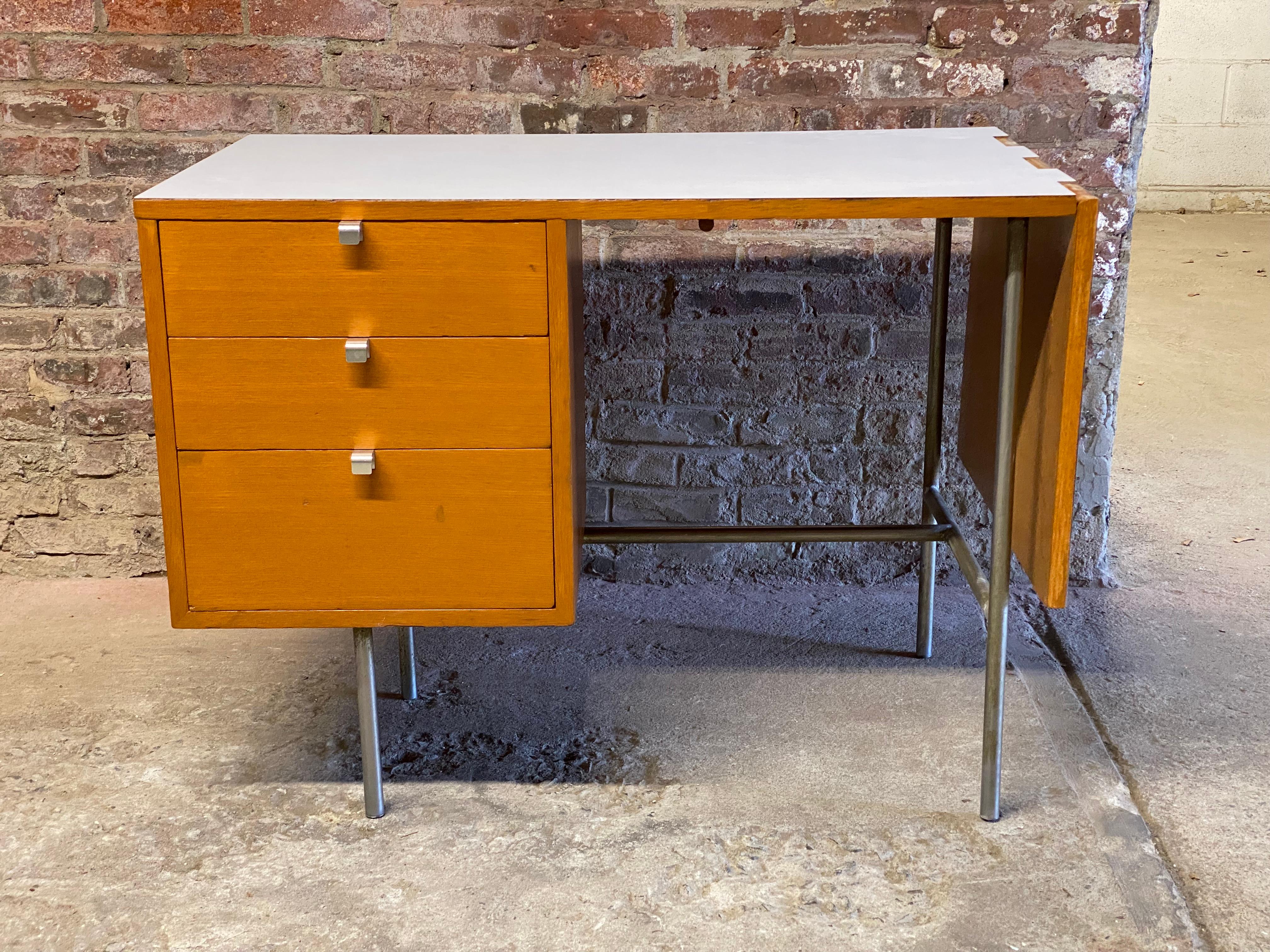 Nice early George Nelson's design for Herman Miller. Oak, aluminum and white laminate top. Three deep drawers. Chrome 'J' pulls. The top drawer pull has the early HM stamp. The side leaf extends with sliding support from underneath to make a larger