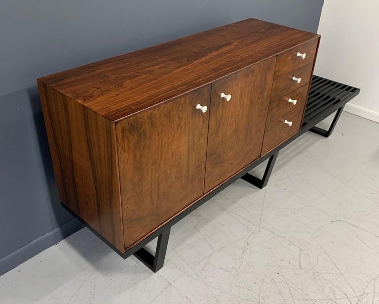 This early Nelson thin edge piece by Herman Miller has beautifully figured rosewood case with a cabinet on the left side with an adjustable shelf and four drawers on the right. Drawers have one of the most elegant pulls Nelson ever designed. 

The