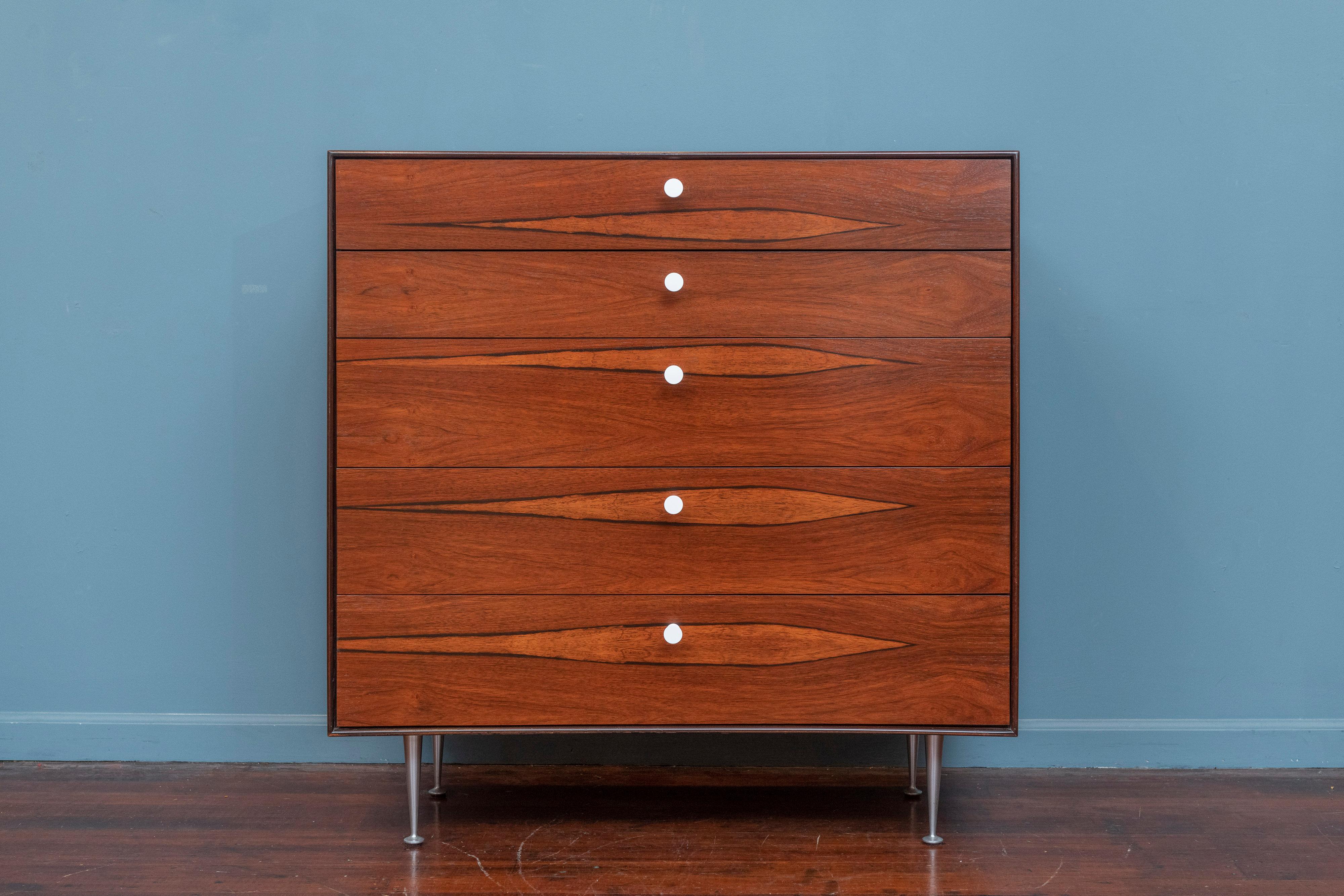 George Nelson design rosewood thin edge tall chest for Herman Miller. Featuring five drawers, two with fitted dividers on aluminum legs and original hourglass pulls. Newly refinished case and drawer fronts with all new drawer runners for smith easy