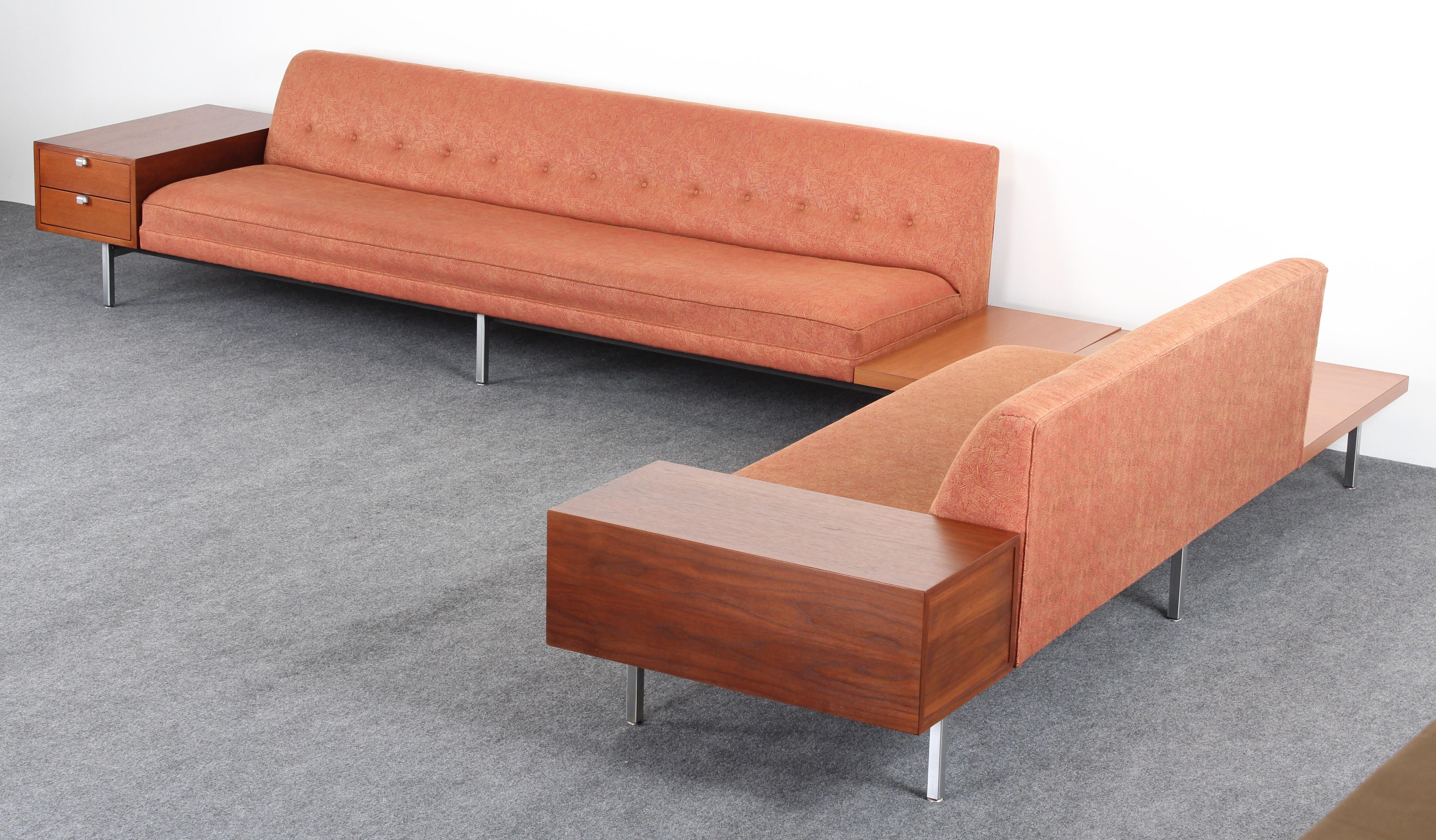 A pair of Mid-Century Modern sofas by George Nelson for Herman Miller. The sofas are constructed with a metal frame and square chrome-plated legs. The vintage sofas have original upholstery. The functional sofa set includes two walnut drawer end