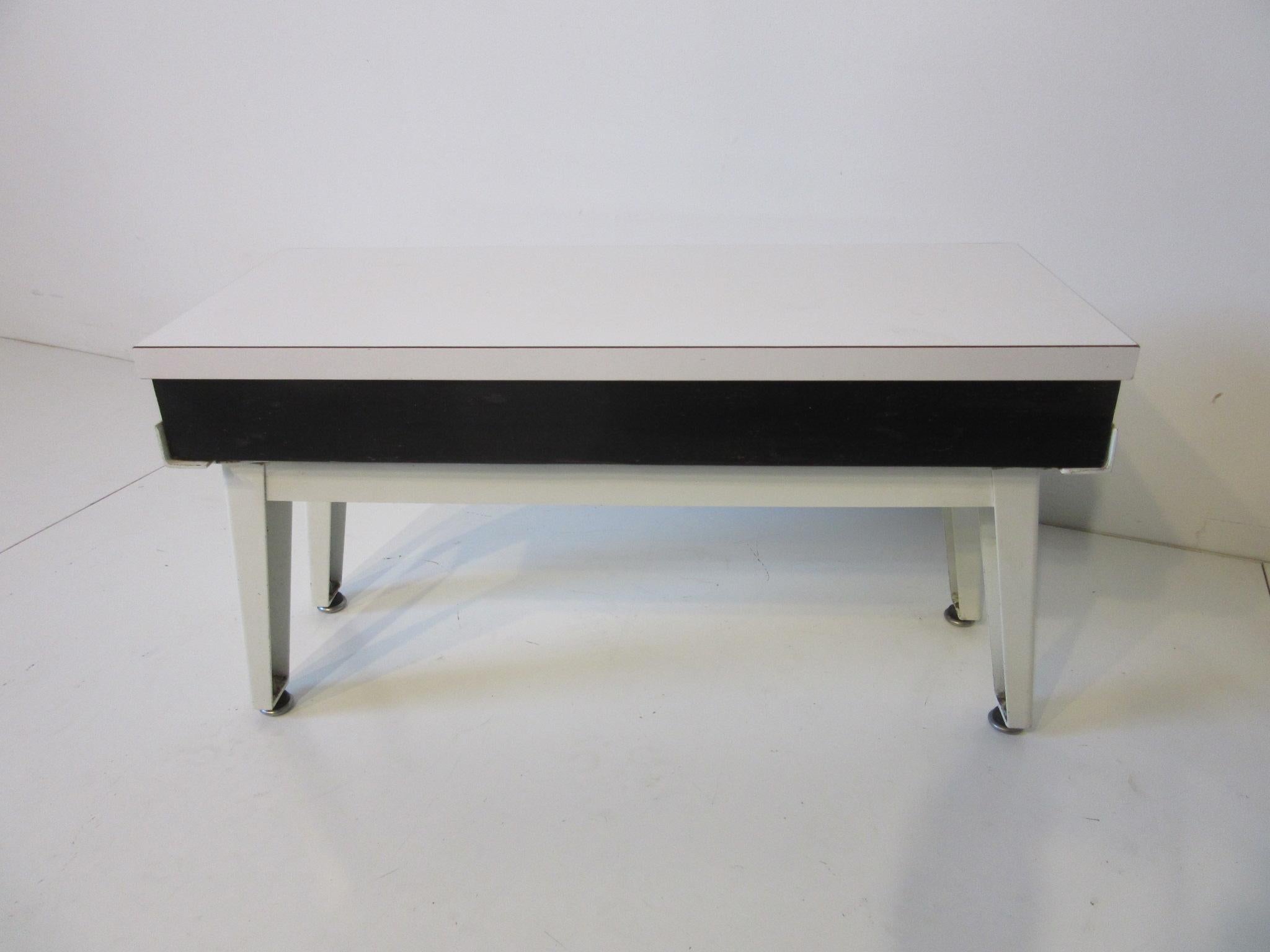A very rare special order steel frame drink side table, satin white metal frame with wood and laminate top and screw in foot pads. This is a well made factory piece which would be great to have to complete your steel frame series collection,