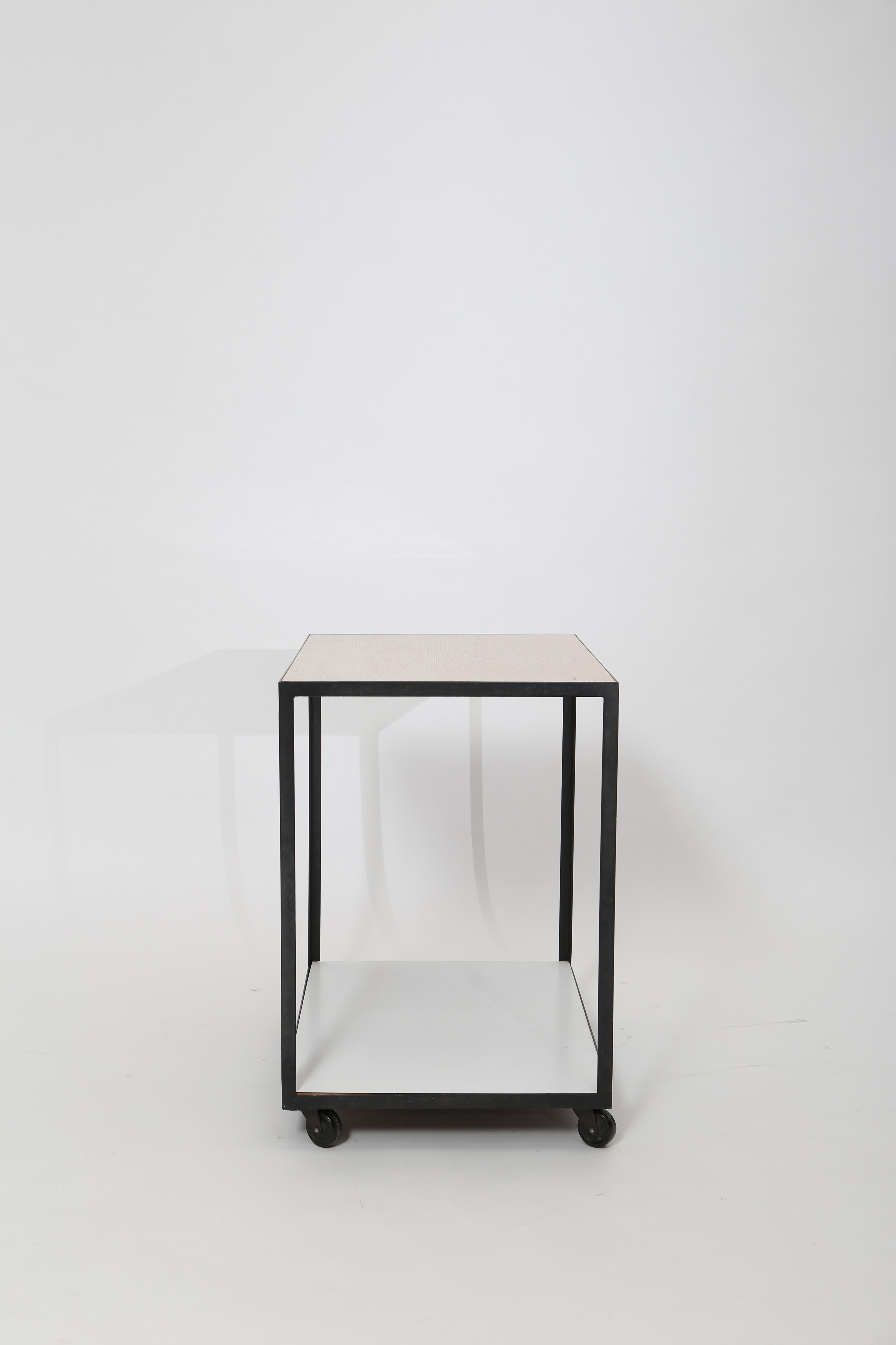 Clean modernist lines; a two-tier steel frame bar trolley by George Nelson. Top surface is a subtle beige cork effect laminate and lower shelf is white Formica. Solid steel frame lacquered black and black casters which glide along smoothly. It’s