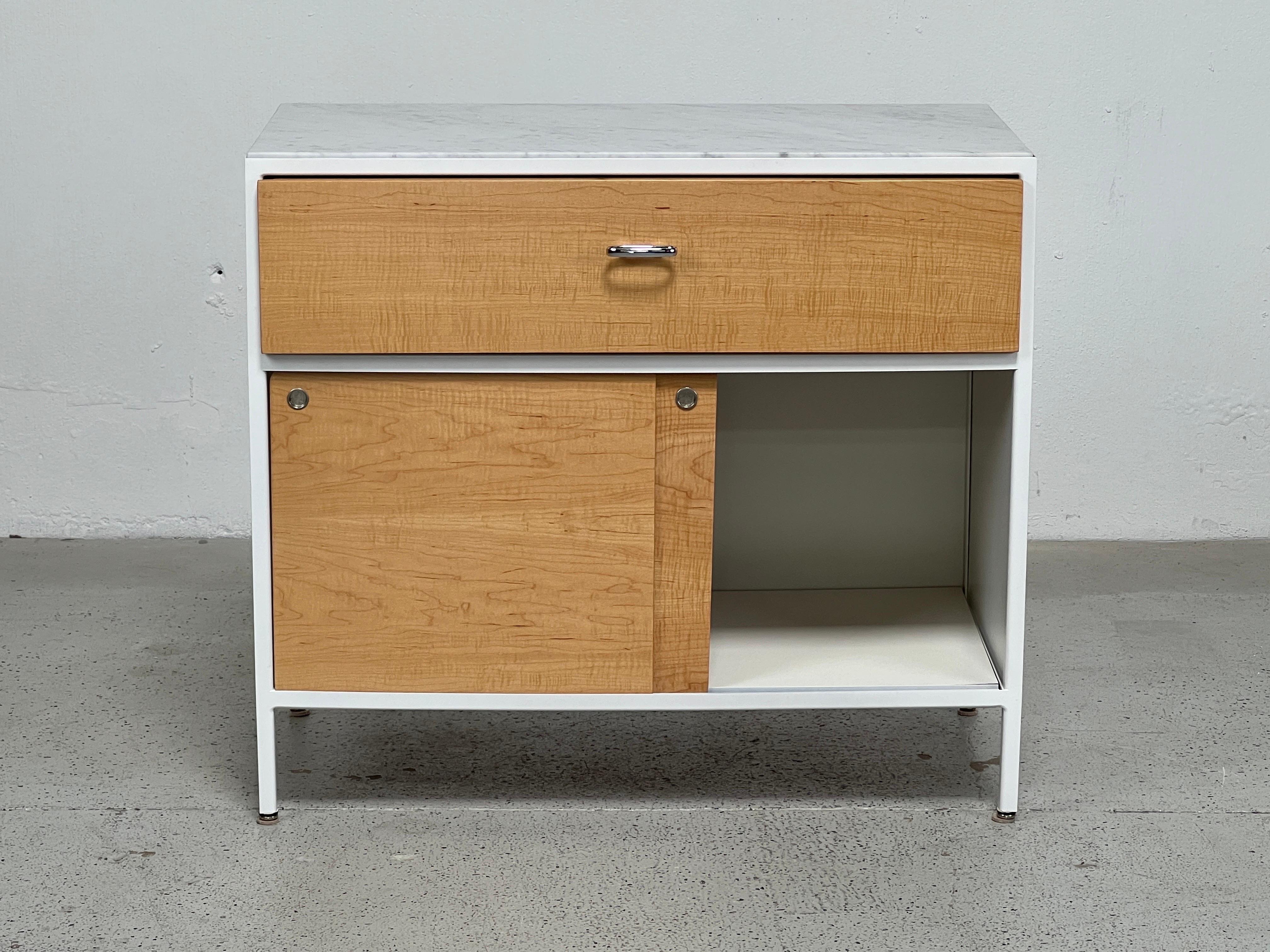 A beautiful steel frame cabinet designed by George Nelson for Herman Miller. All cabinets restored with maple drawer fronts and marble tops. Matching pair of dressers available separately. 