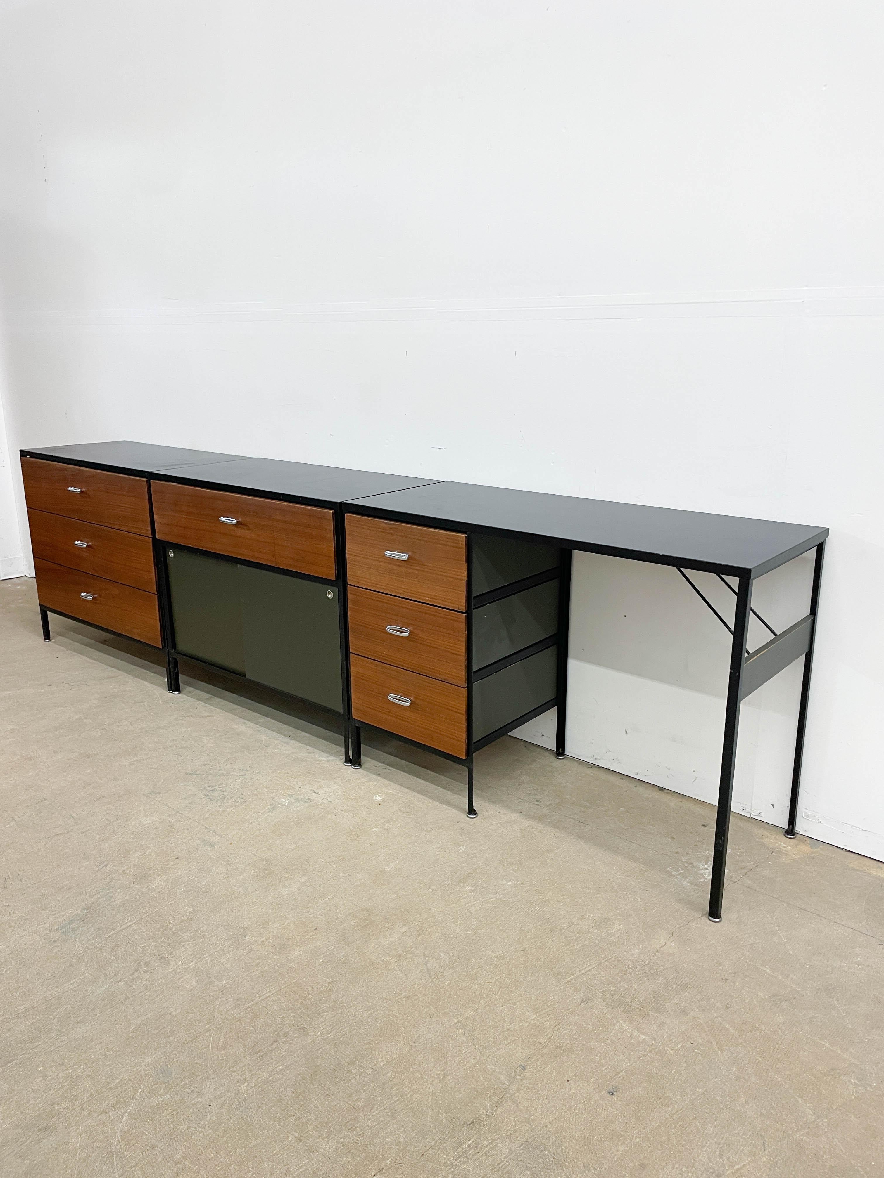 Designed by George Nelson for Herman Miller in the early 1950s, this hard to find set of matching dresser, cabinet and desk exemplify Nelson's minimalist brand of modernism. Utilitarian steel case frame accepts walnut faced drawers and painted doors