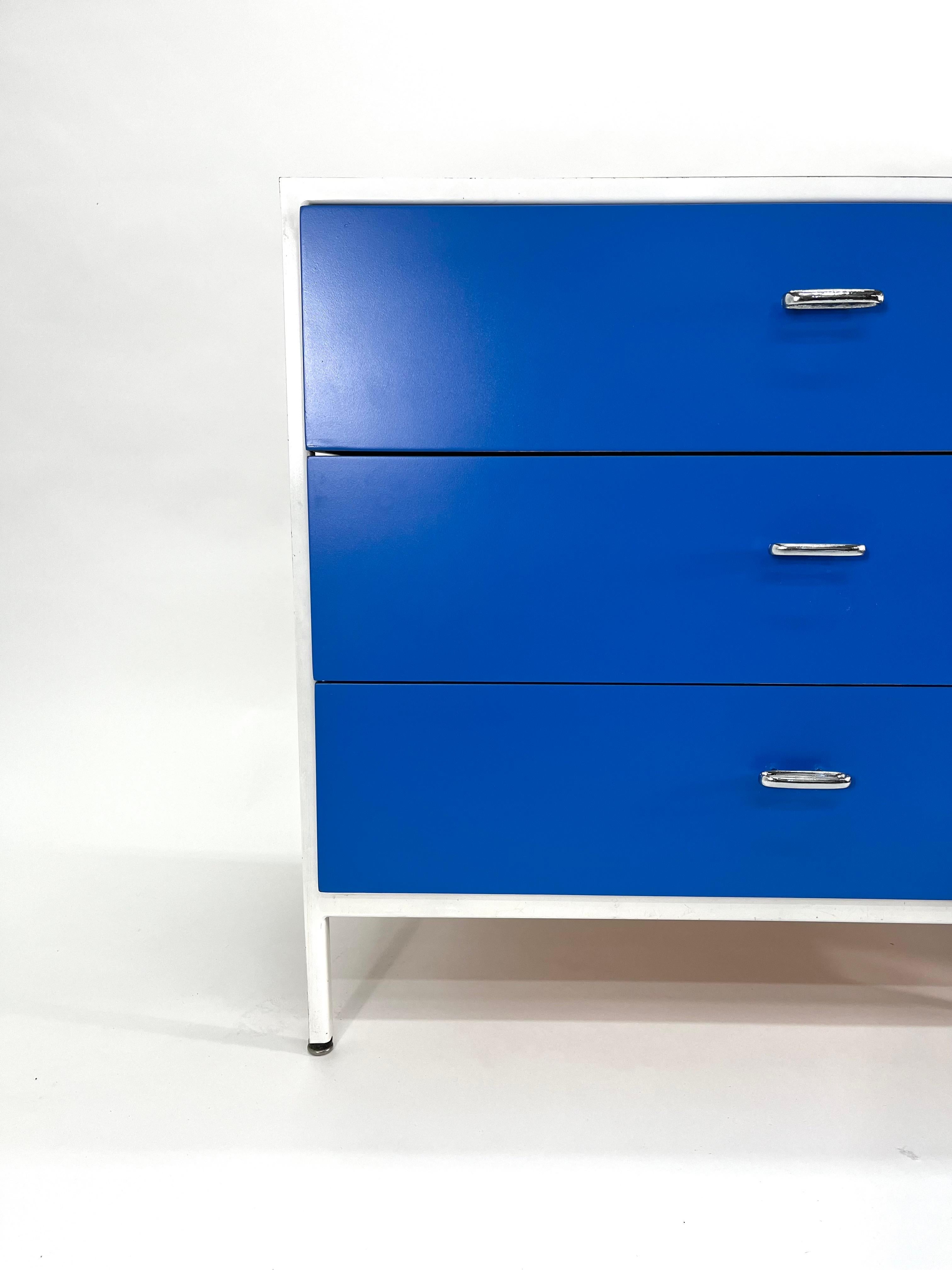 3 drawer Herman Miller dresser in white, gray and blue with a white laminate top. 

This is a sold dresser designed by George Nelson Associates for Herman Miller dating back to the 1950s. It has three drawers suspended in a steel frame. This unusual