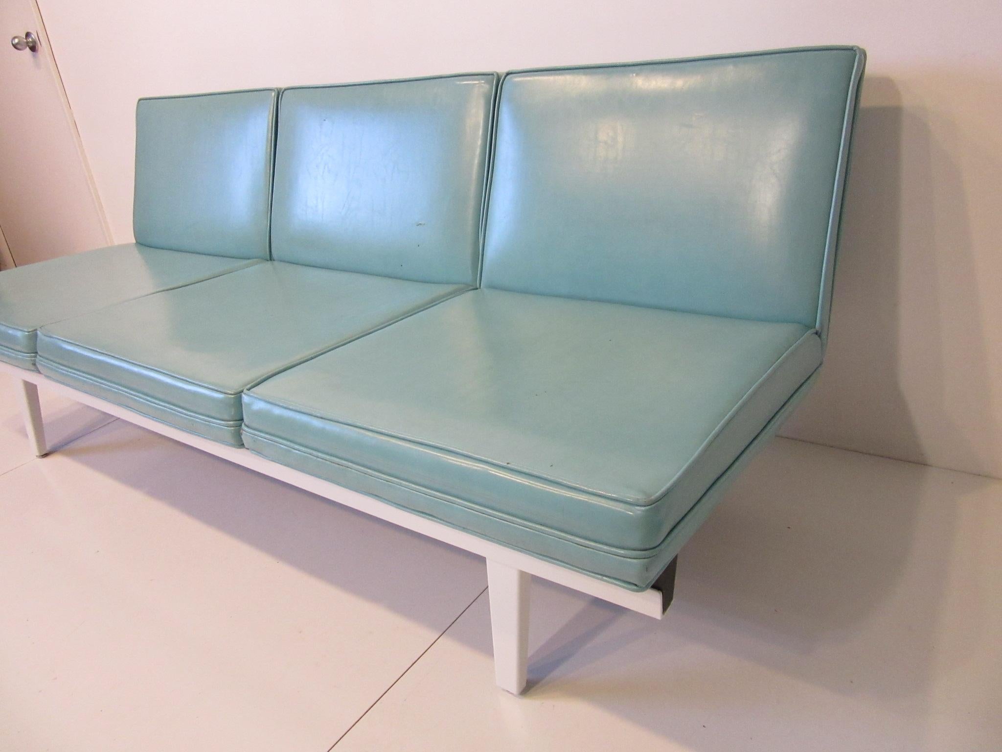 A three seat cushion Nelson steel frame sofa with satin white frame, adjustable metal and rubber foot pads manufactured by the Herman Miller furniture Company. A design from the 1950s that has stood the test of time and is still as fresh today as it