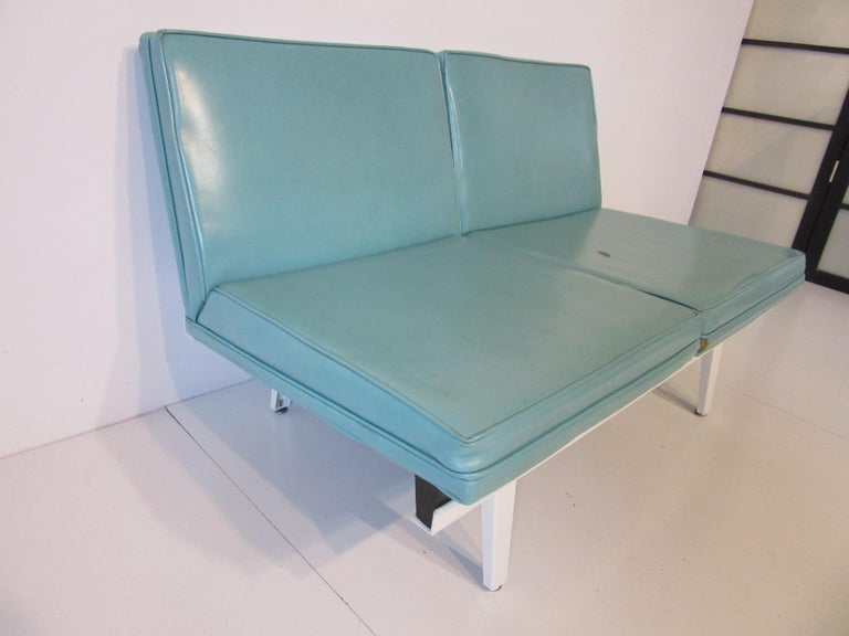 A Nelson designed sofa / loveseat with two turquoise Naugahyde wood framed seats with satin white metal frame having metal and rubber foot pads. This modular designed seating system still has a fresh look having its beginnings from the early 1950s,