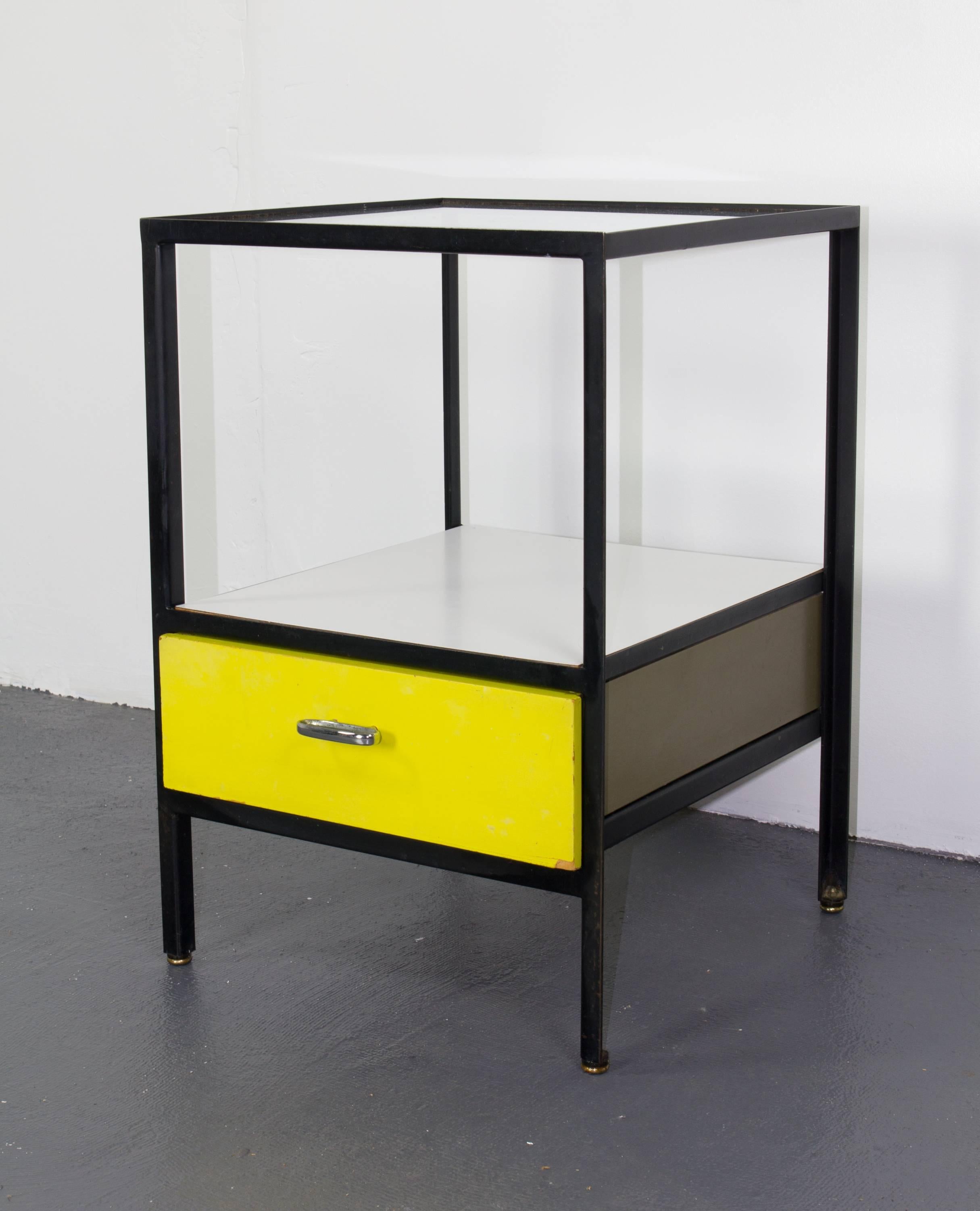 Pair of steel frame nightstands by George Nelson for Herman Miller with yellow lacquered wood drawers, framed in enameled steel with glass tabletops and white laminate lower shelves.