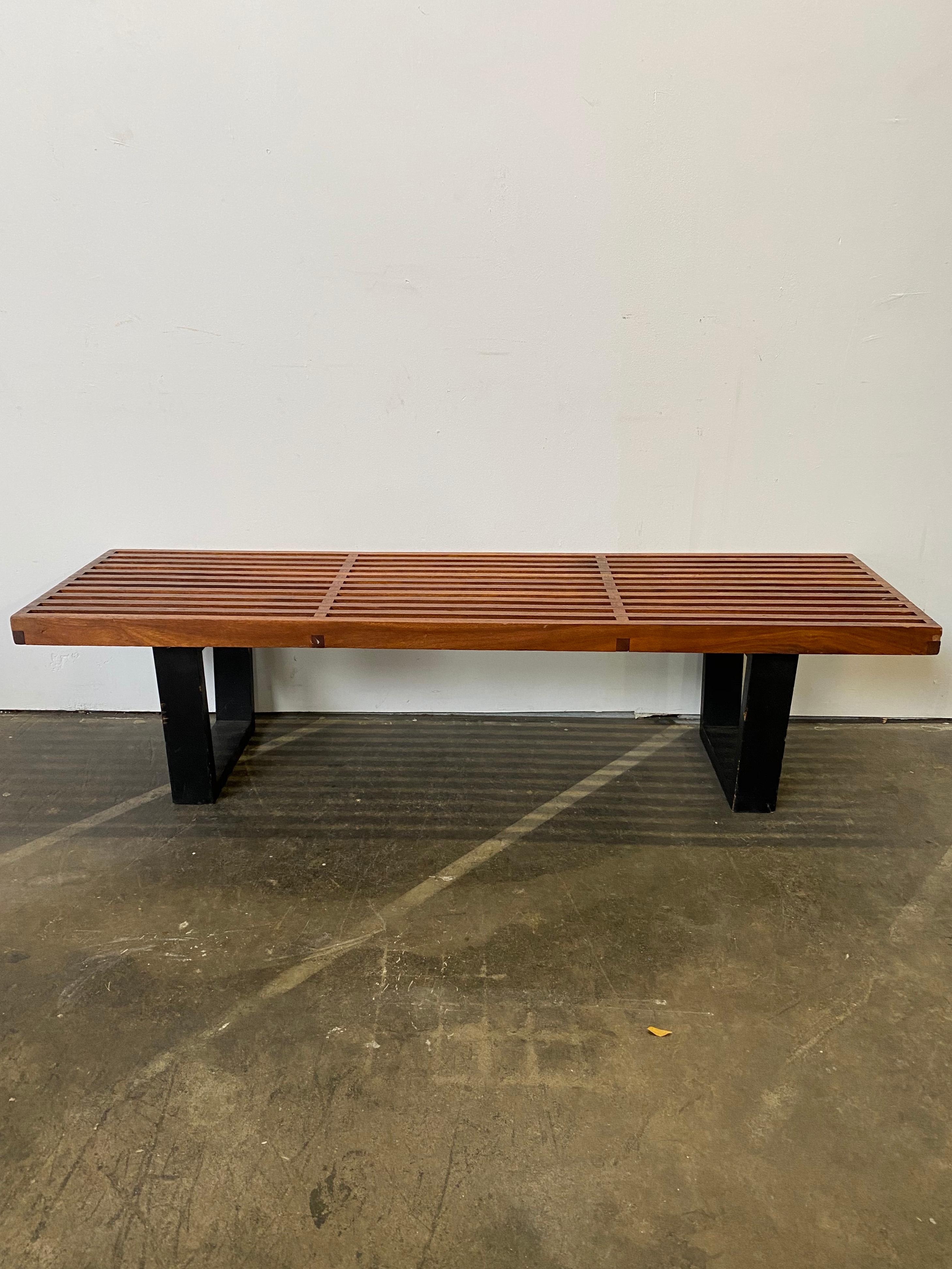 Gorgeous vintage slat bench in the style of George Nelson for Herman Miller. Featuring a beautiful top rich with patina and age, atop sturdy and solid black painted legs. Heavy and well constructed. Normal wear from age. Features richer and darker