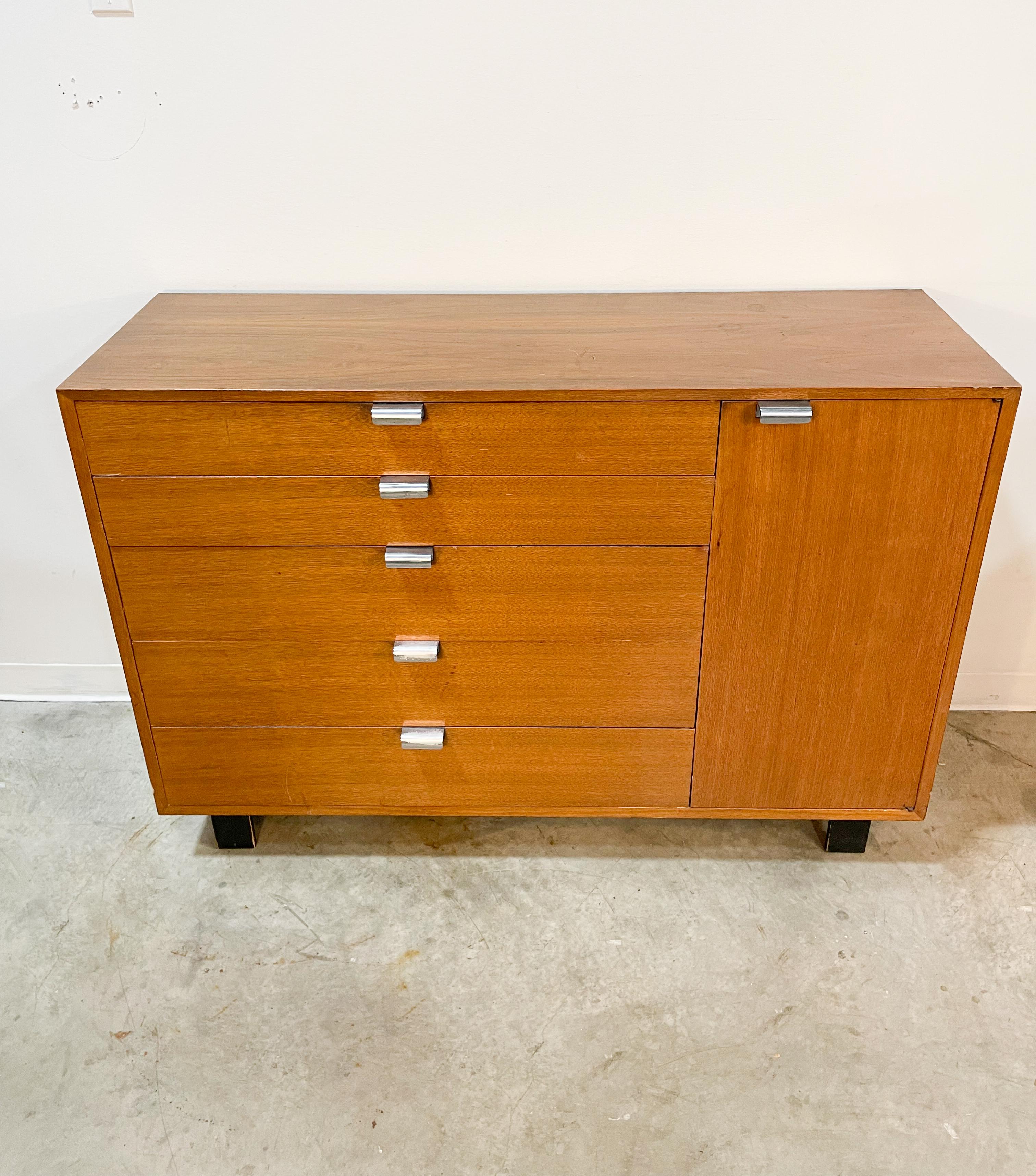 Tall dresser combo designed by George Nelson for the BCS line made by Herman Miller in the late 1940s. Featuring excellent storage over five drawers and a separate cupboard with three adjustable shelves, this walnut and polished aluminum cabinet is