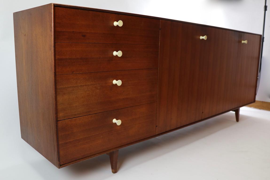 Nice thin edge credenza designed by George Nelson for Herman Miller. Four drawers with flanking doors that open to reveal adjustable shelved storage. This example shows cosmetic wear to finish, no structural damage, chips, gouges or major issues. We