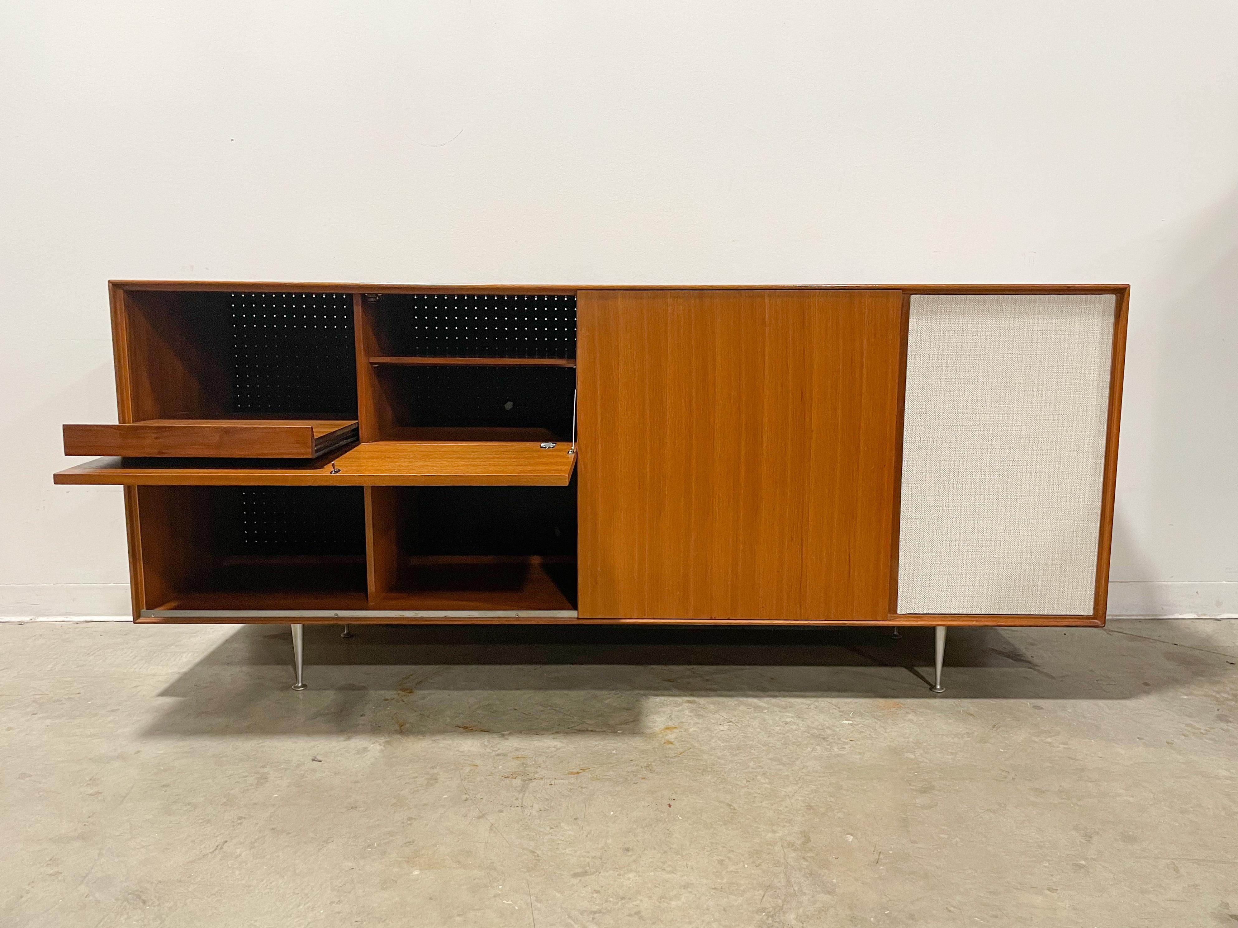 Rare thin edge line record cabinet designed by George Nelson and made by Herman Miller in the 1950s. Walnut case on classic aluminum legs with drop down record player and amplifier section, record storage and component rack. Record player drawer