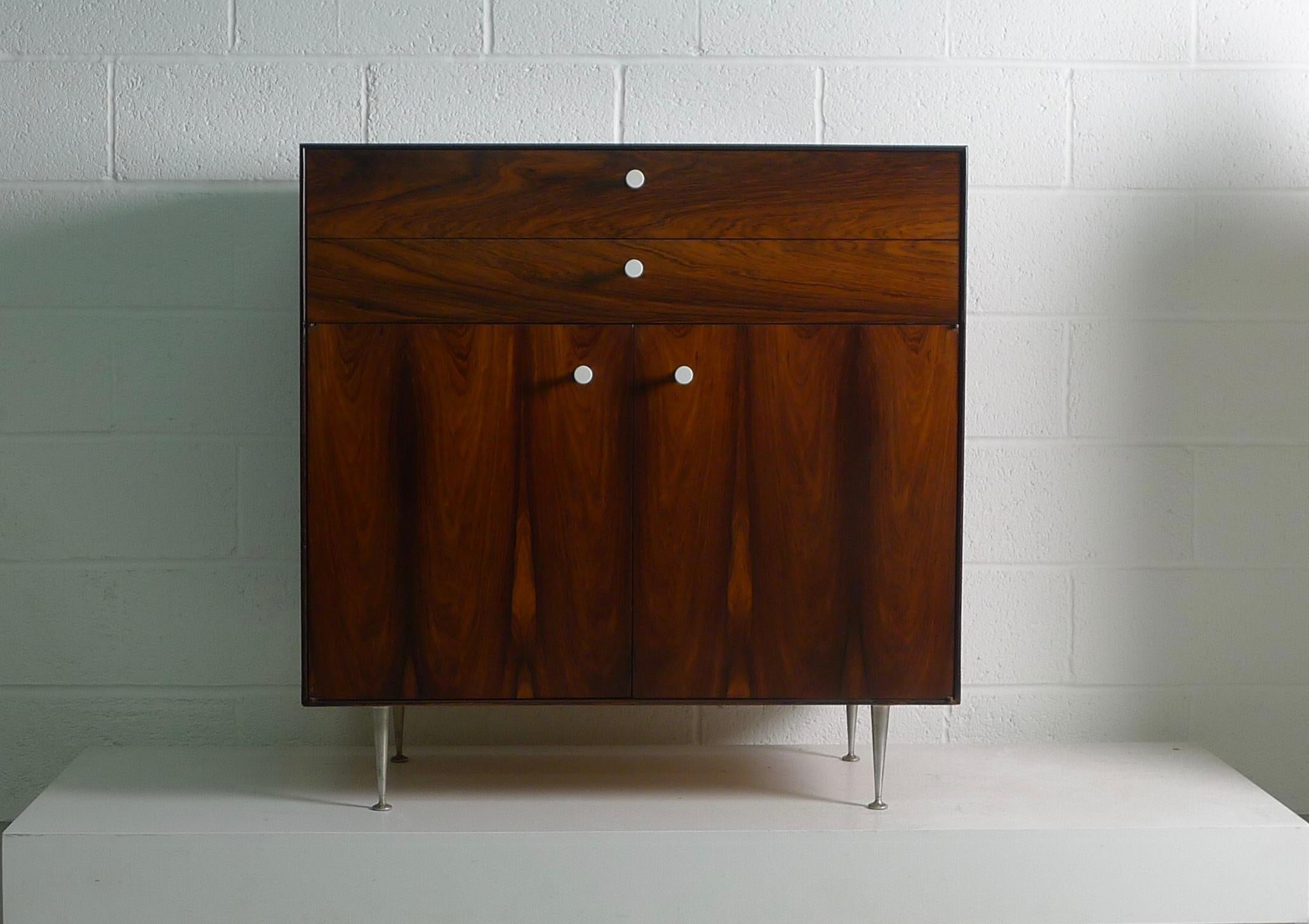 George Nelson for Herman Miller , USA circa 1955 a Thin Edge cabinet in rarely seen format of 2 drawers over 2 doors . Upper drawer with dividers and label .
Rosewood veneers are bookmatched and all hardware and internals are original .
Recently