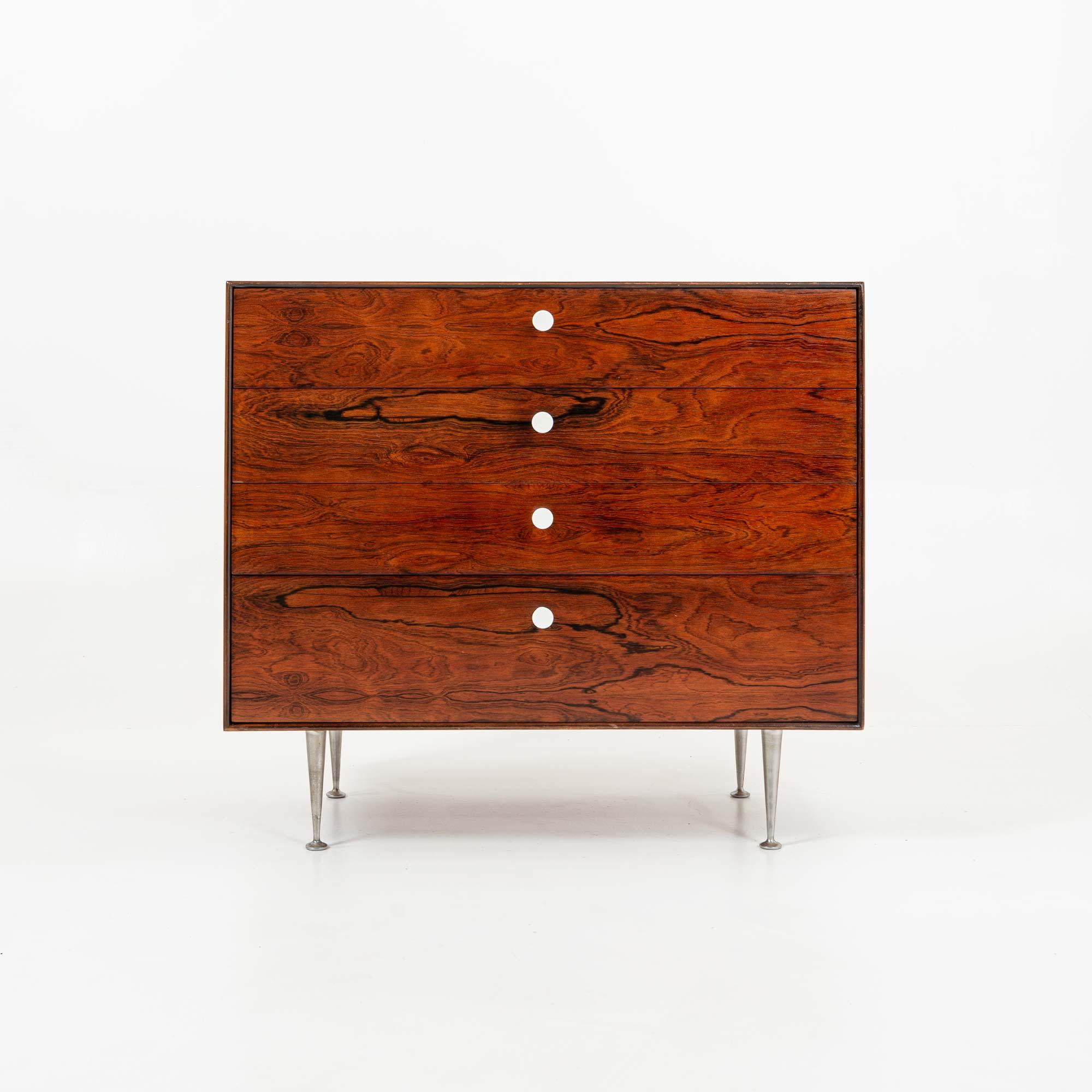 A George Nelson four-drawer Thin Edge rosewood dresser, circa 1955. This stunning piece has dynamic, rich rosewood graining, four drawers, original porcelain pulls, and iconic Thin Edge metal legs. The Foil label remains inside the top drawer