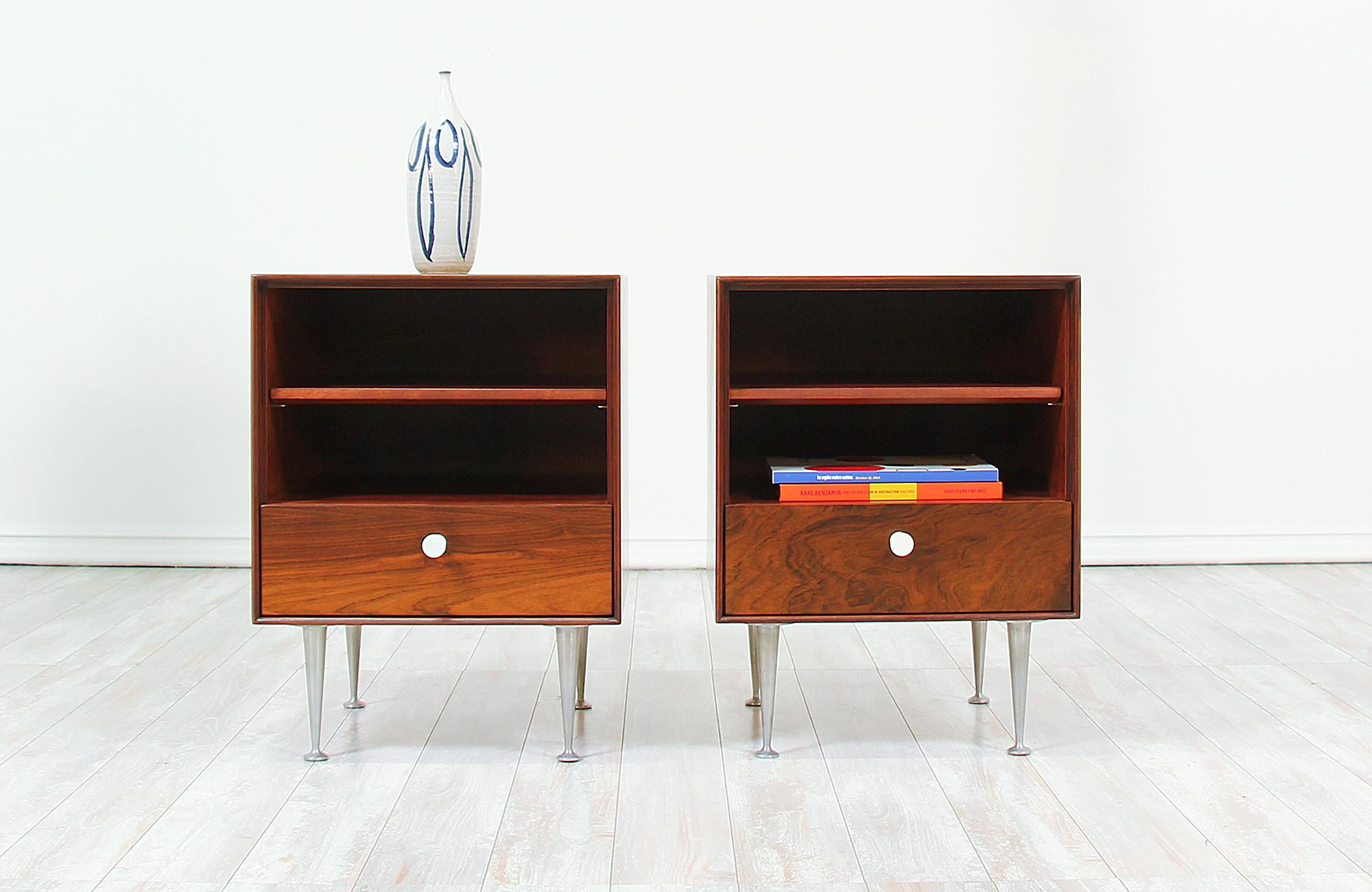 Elegant pair of nightstands designed by George Nelson for Herman Miller in the United States circa 1950s. This beautiful pair belongs to Nelson’s Thin Edge collection crafted in Brazilian rosewood with its original white porcelain pulls and polished