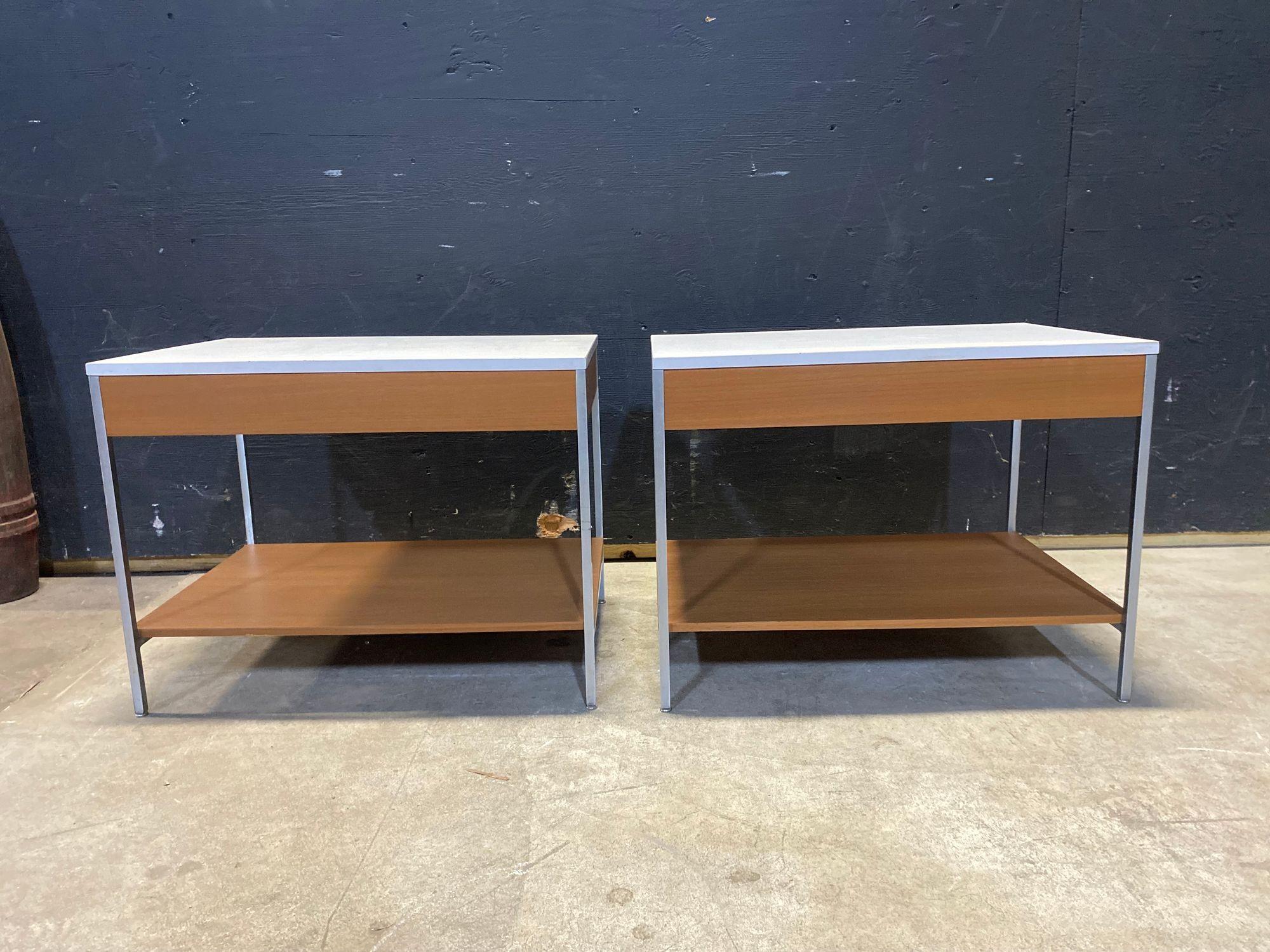 A beautiful pair of 1950's nightstands. Designed by George Nelson for Herman Miller. Walnut casework with a single drawer over a single shelf, finished with a white laminate top and polished steel framework. Clean, classic, mid century design.