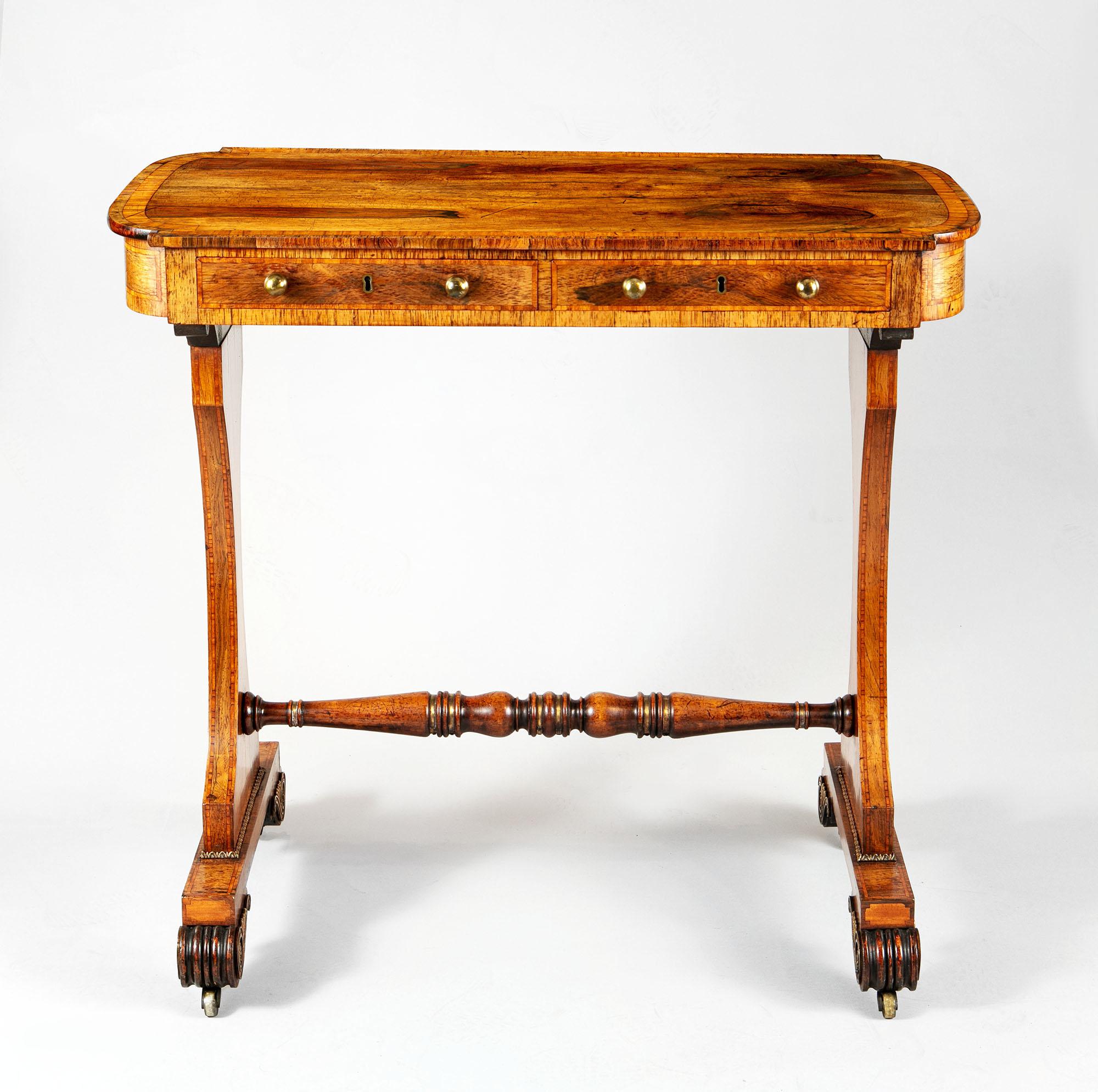 A very fine early 19th-century Regency writing table of small scale attributed to the workshop of George Oakley. The fine top with D curved ends houses two short drawers in rosewood with banding and brass ball handles, the whole raised on pedestal
