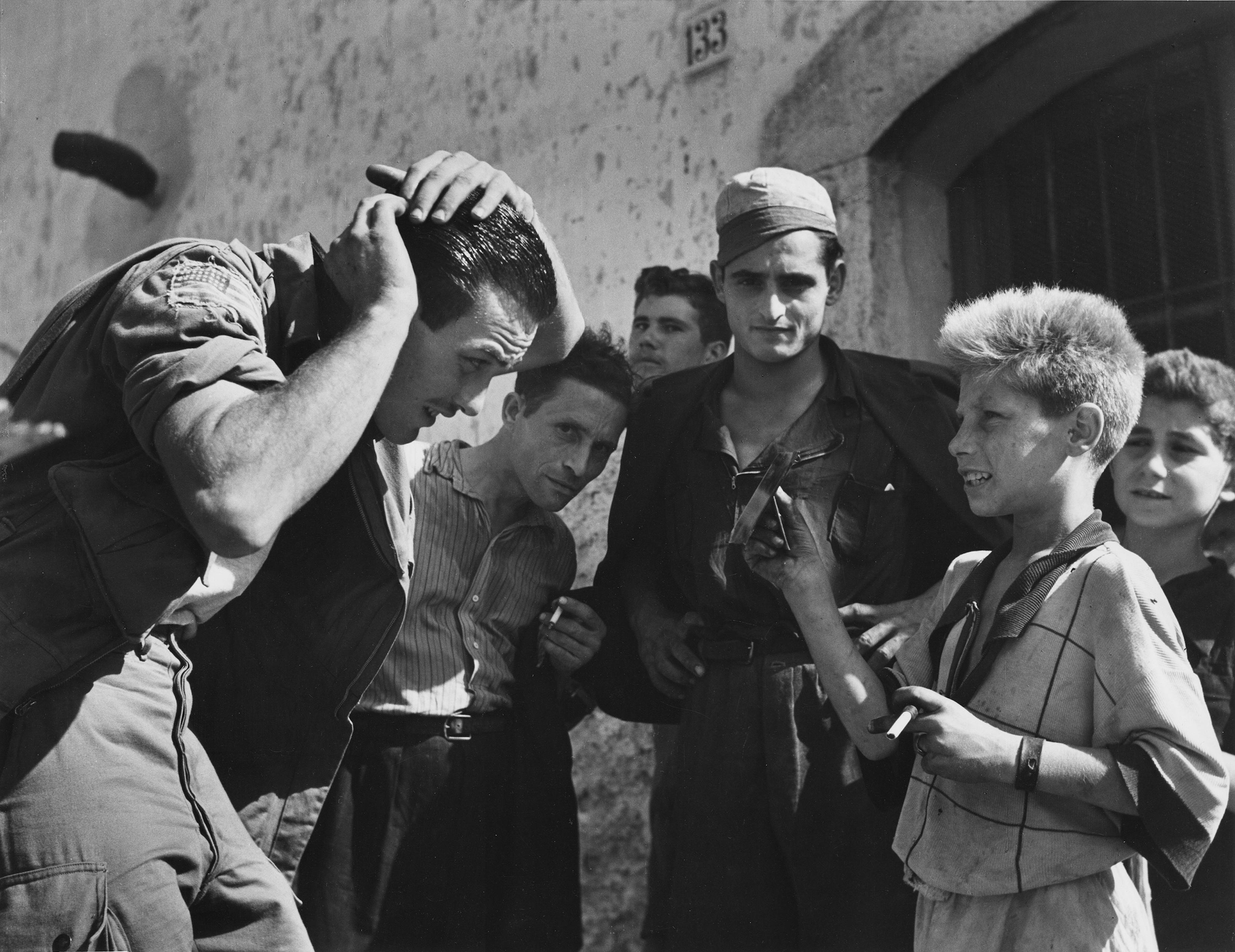Un soldado estadounidense destinado en Nápoles se arregla con la ayuda de los lugareños, 1943.

Todos los tamaños y ediciones disponibles:
16" x 20", Tamaño de edición 25
30 "x 40", Tamaño de la edición 25
40" x 60", Tamaño de la edición 25

Esta