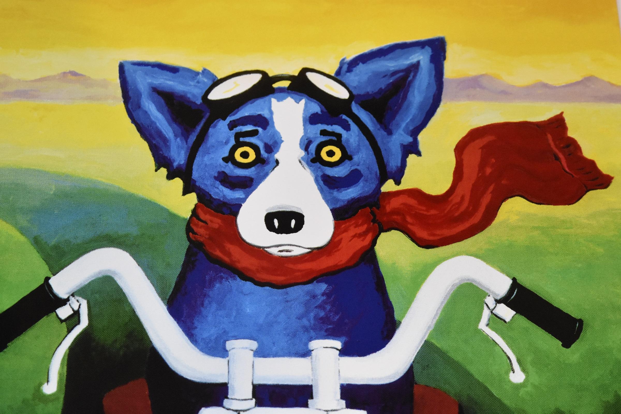 This Blue Dog work consists of one blue dog sitting on a motorcycle sporting a red scarf around its neck. There is also scenery of mountains in brown and green coloring. The dog has soulful yellow eyes.  This pop art animal original silkscreen print
